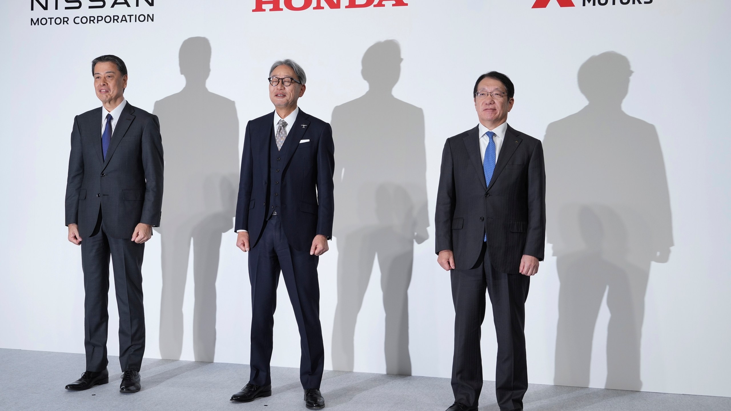 Nissan Chief Executive Makoto Uchida, left, Honda Chief Executive Toshihiro Mibe, center, and Takao Kato, CEO of Mitsubishi Motors, right, pose for photographers during a joint news conference in Tokyo, Japan, Monday, Dec. 23, 2024. (AP Photo/Eugene Hoshiko)