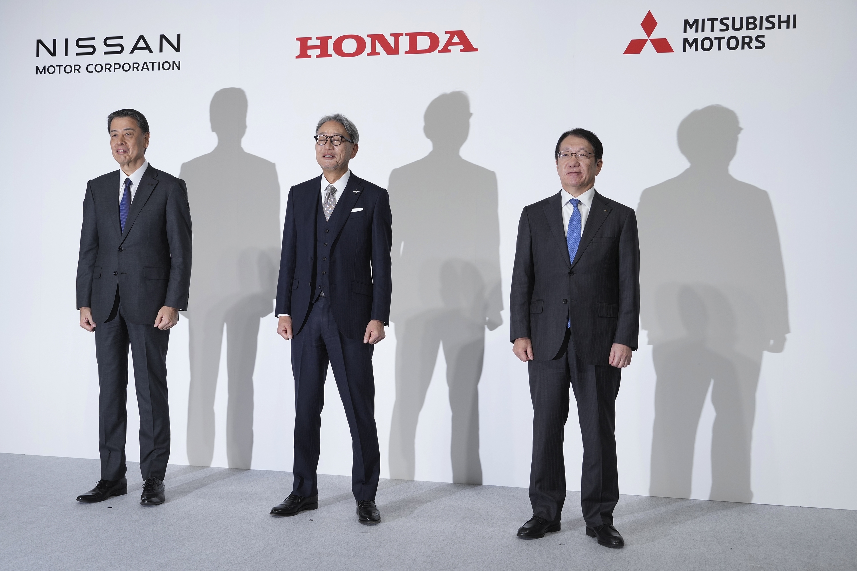 Nissan Chief Executive Makoto Uchida, left, Honda Chief Executive Toshihiro Mibe, center, and Takao Kato, CEO of Mitsubishi Motors, right, pose for photographers during a joint news conference in Tokyo, Japan, Monday, Dec. 23, 2024. (AP Photo/Eugene Hoshiko)