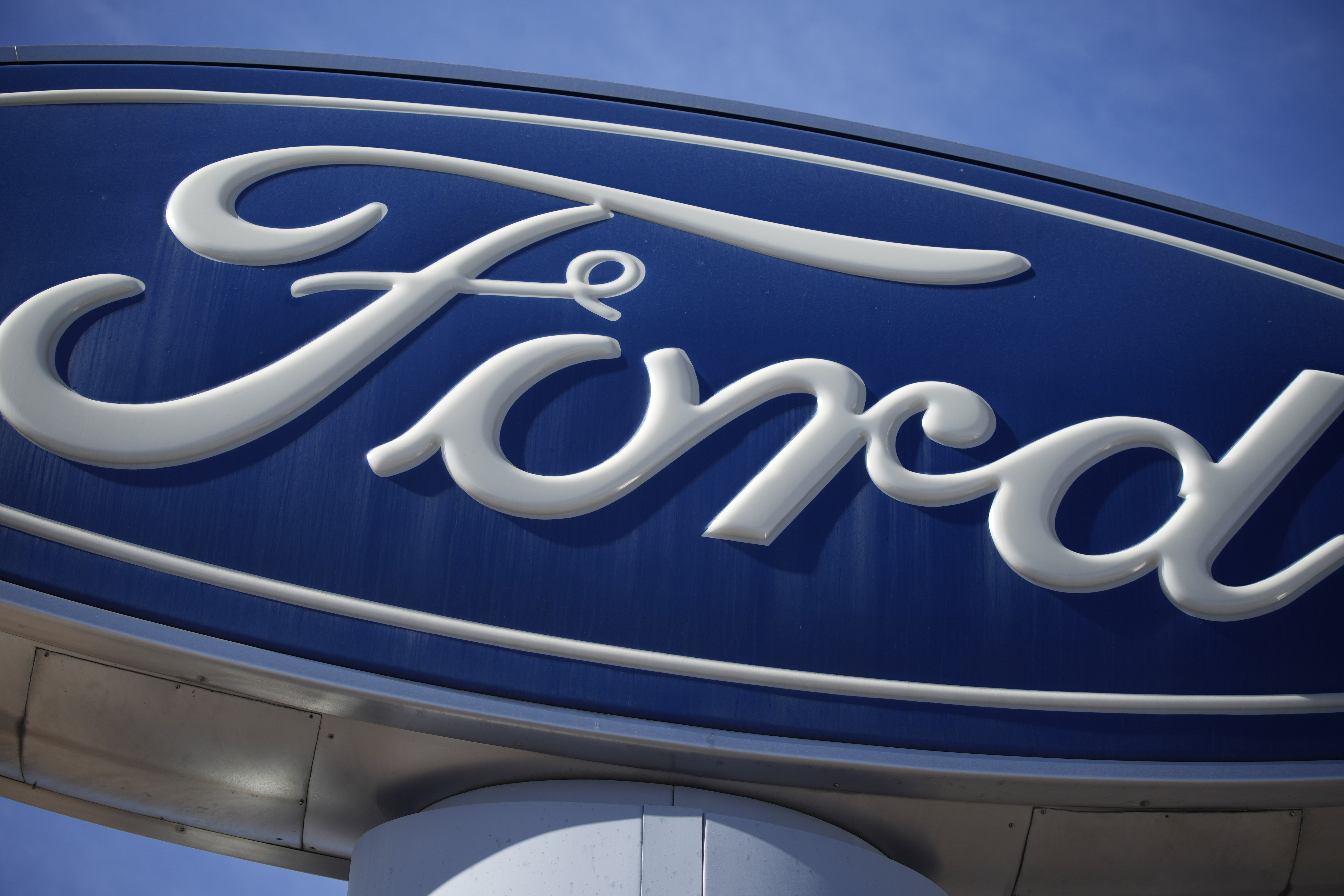 FILE - The Ford company logo is seen, Oct. 24, 2021, on a sign at a Ford dealership in southeast Denver. (AP Photo/David Zalubowski, File)