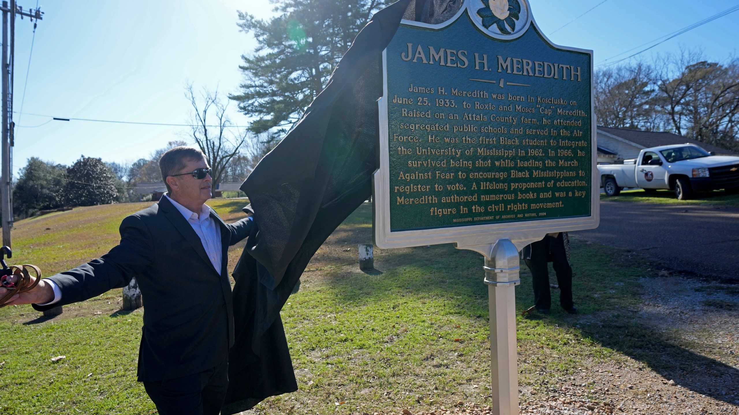 Kosciusko, Miss., Mayor Tim Kyle, unveils a Mississippi Department of Archives and History marker recognizing the birthplace and civil rights movement legacy of James Meredith, who became the first Black student to enroll at the University of Mississippi in 1962, Friday, Dec. 20, 2024, in Kosciusko, Miss. (AP Photo/Rogelio V. Solis)