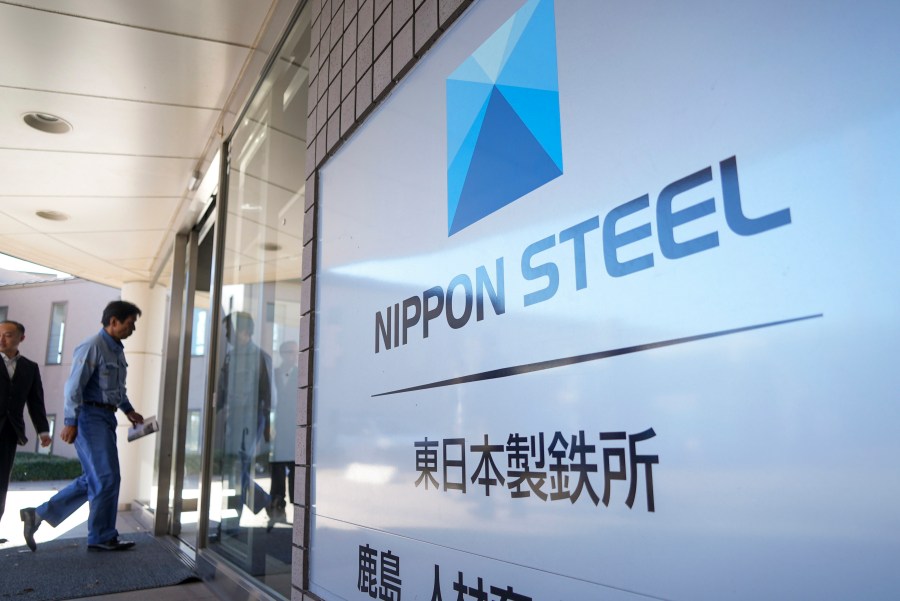 A staff enters doorway next to Nippon Steel logo at the company's Kashima Plant in Kashima, Japan on Friday, Dec. 6, 2024. (AP Photo/Ayaka McGill)