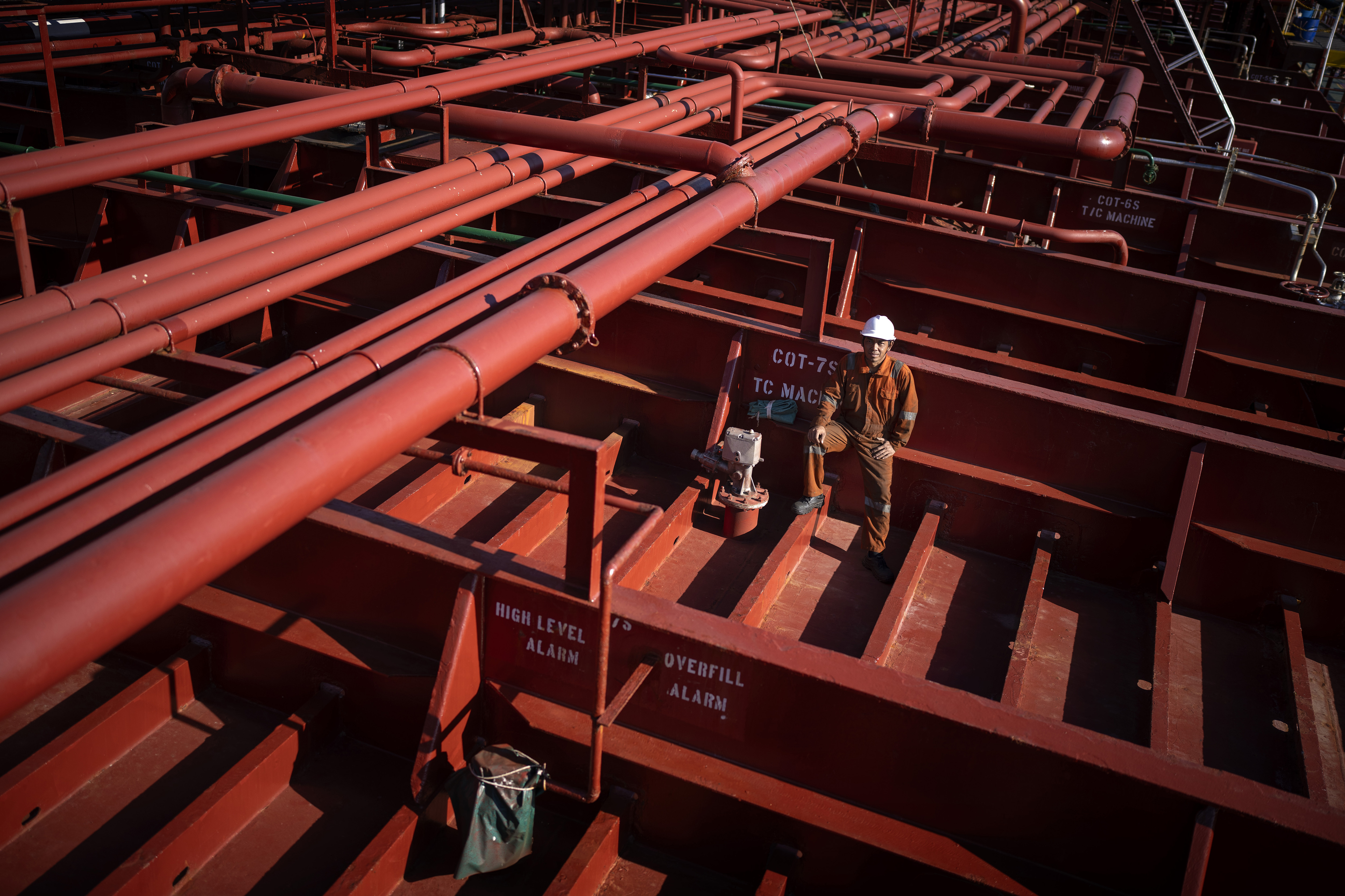 Rahil Gunawan, 55, of Indonesia, poses on the deck of the chemical tanker on which he works as a deckhand while calling at the port of Barcelona, Spain, Friday, Sept. 27, 2024. Gunawan, who has five children and has been working on cargo ships for more than 25 years, spends seven to ten months at sea per year. (AP Photo/Emilio Morenatti)