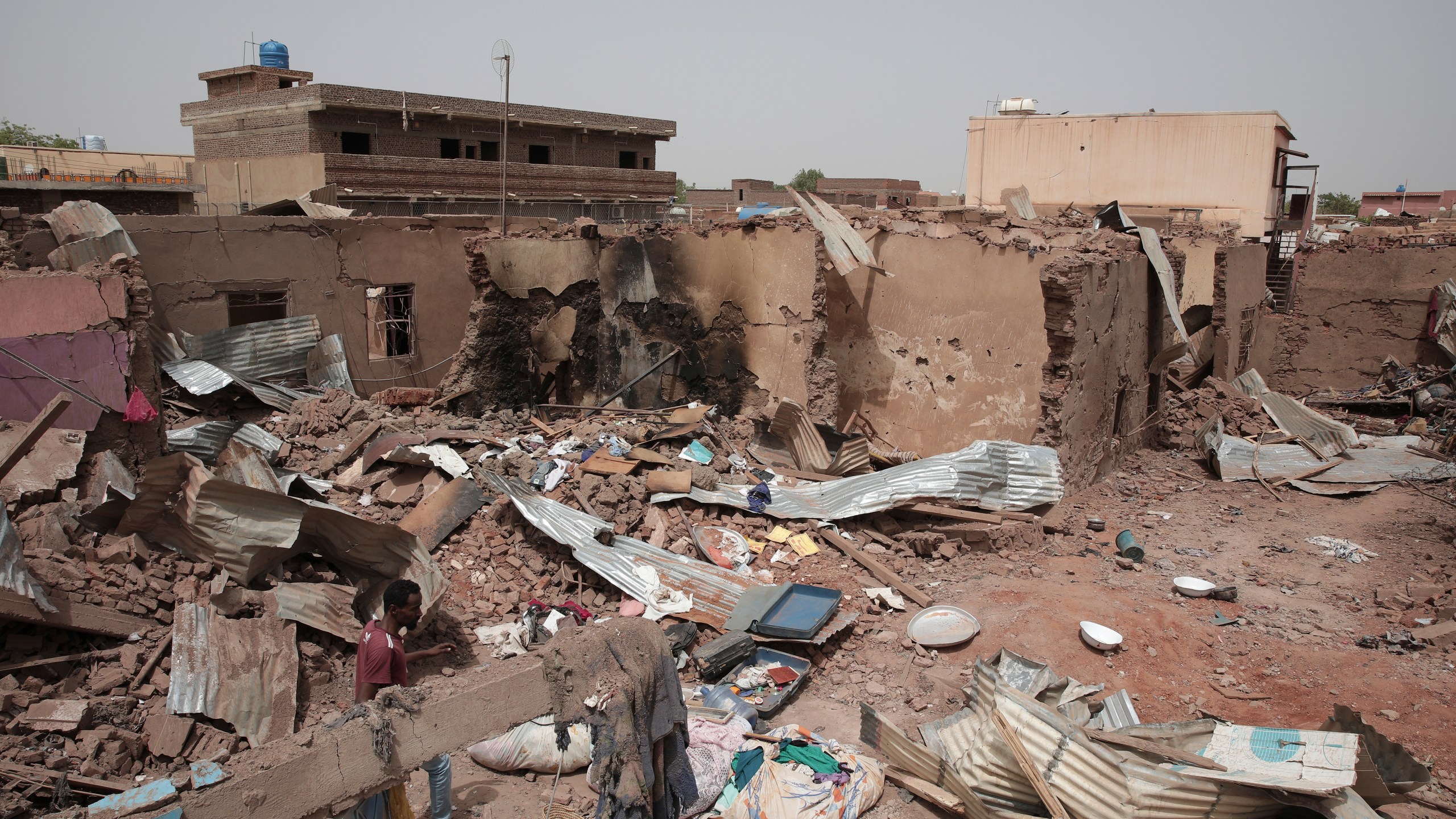 File - A man walks by a house hit in recent fighting in Khartoum, Sudan, an area torn by fighting between the military and the notorious paramilitary Rapid Support Forces, April 25, 2023. (AP Photo/Marwan Ali, File)