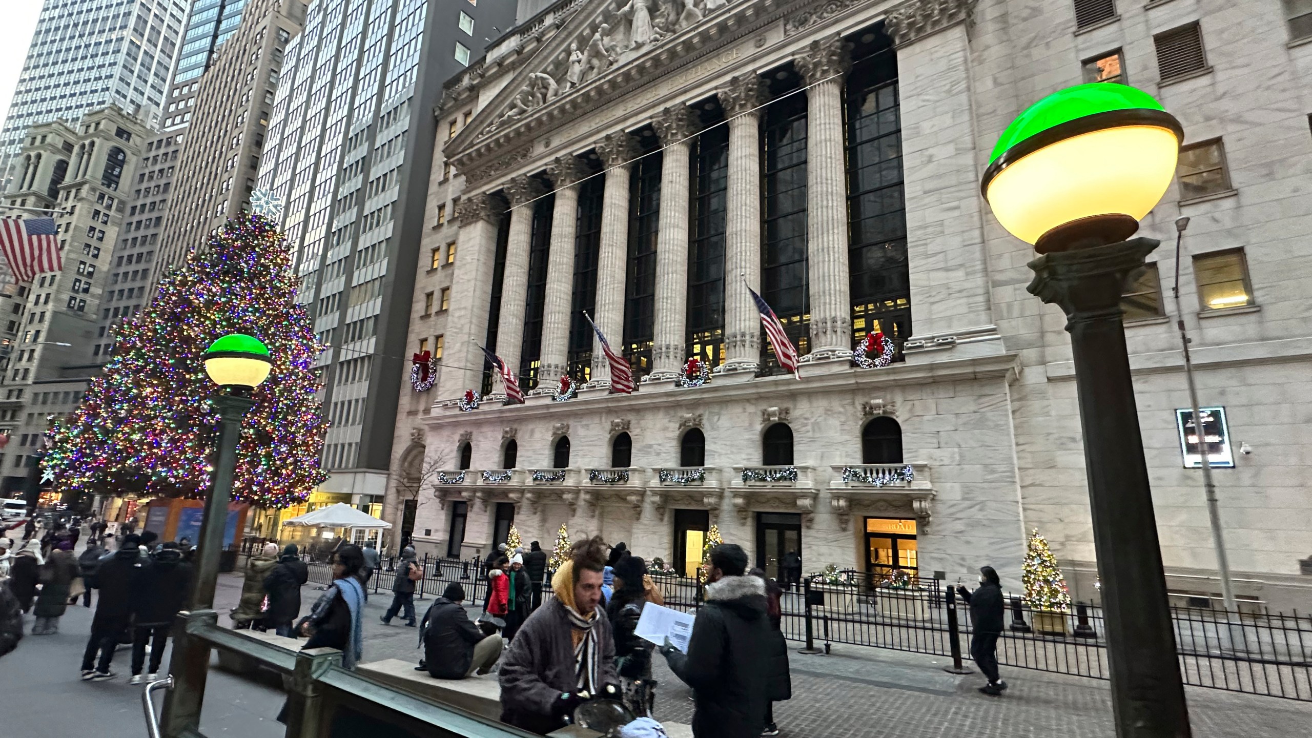 Lights marking the entrance to a subway station frame the New York Stock Exchange in New York's Financial District on Monday, Dec. 23, 2024. (AP Photo/Peter Morgan)