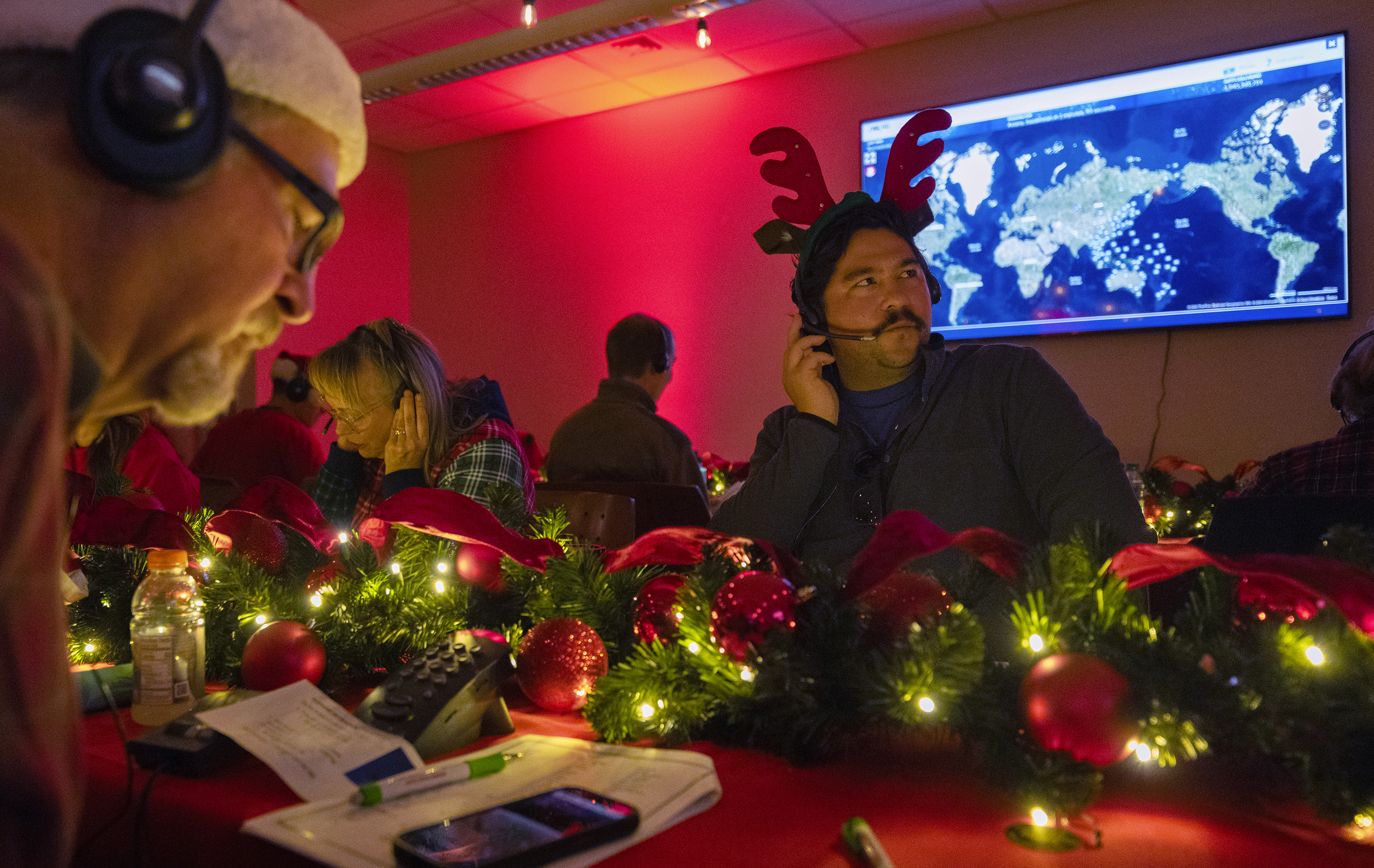 Volunteers answer phone calls from around the world Tuesday, Dec. 24, 2024, at the NORAD Tracks Santa center at Peterson Space Force Base in Colorado Springs, Colo. (Christian Murdock /The Gazette via AP)