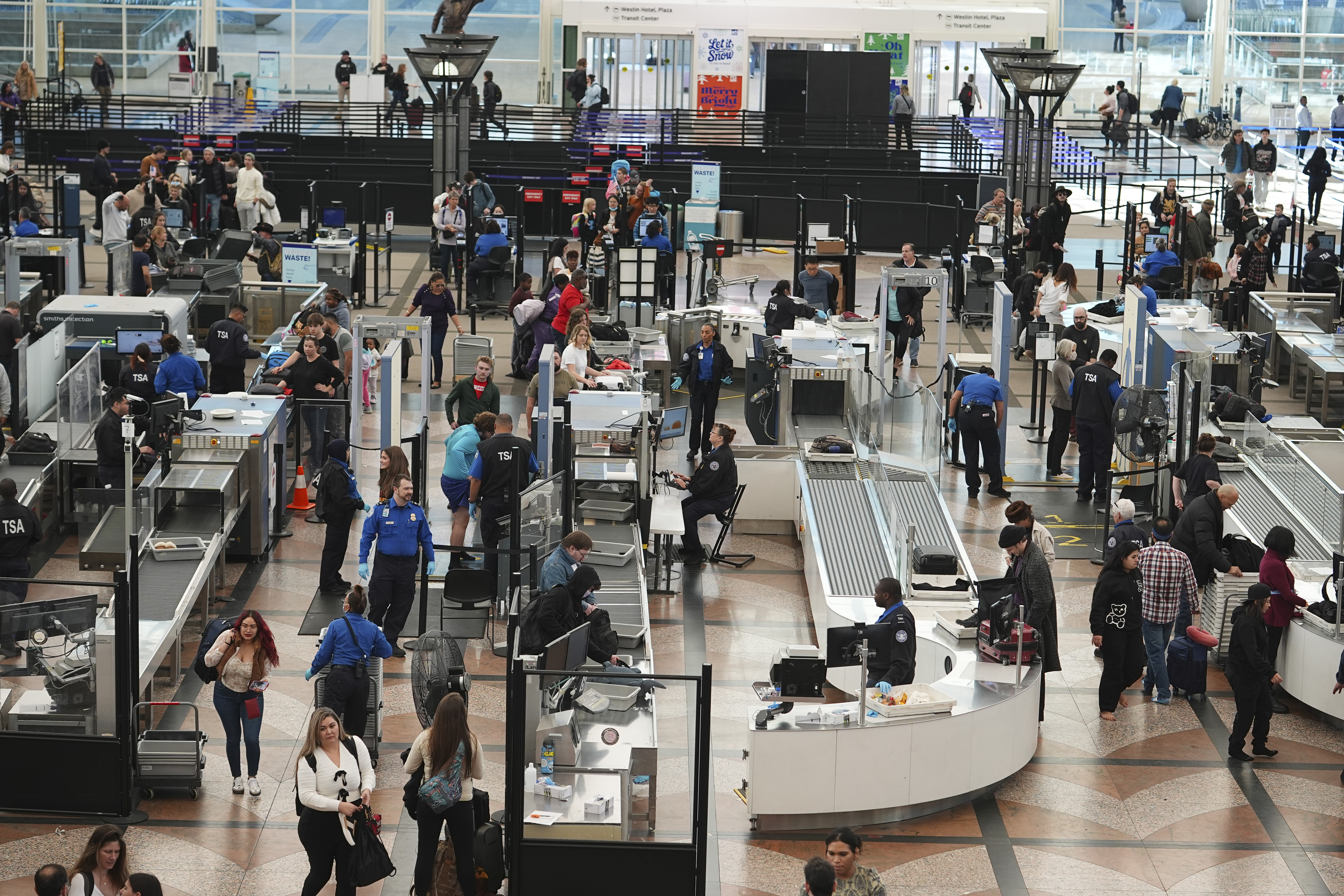 Travelers queue up to pass through the south security checkpoint in the main terminal of Denver International Airport Tuesday, Dec. 24, 2024, in Denver. (AP Photo/David Zalubowski)