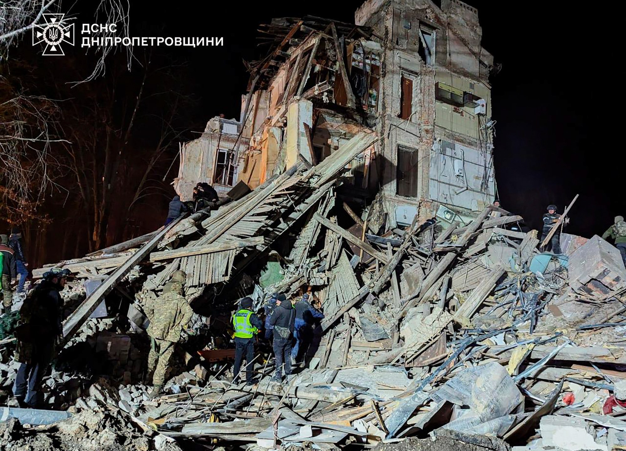 In this image provided by the Ukrainian Emergency Service on Wednesday, Dec. 25, 2024, firefighters work on a site of an apartment building destroyed by a Russian attack in Kryvyi Rih, Ukraine. (Ukrainian Emergency Service via AP)