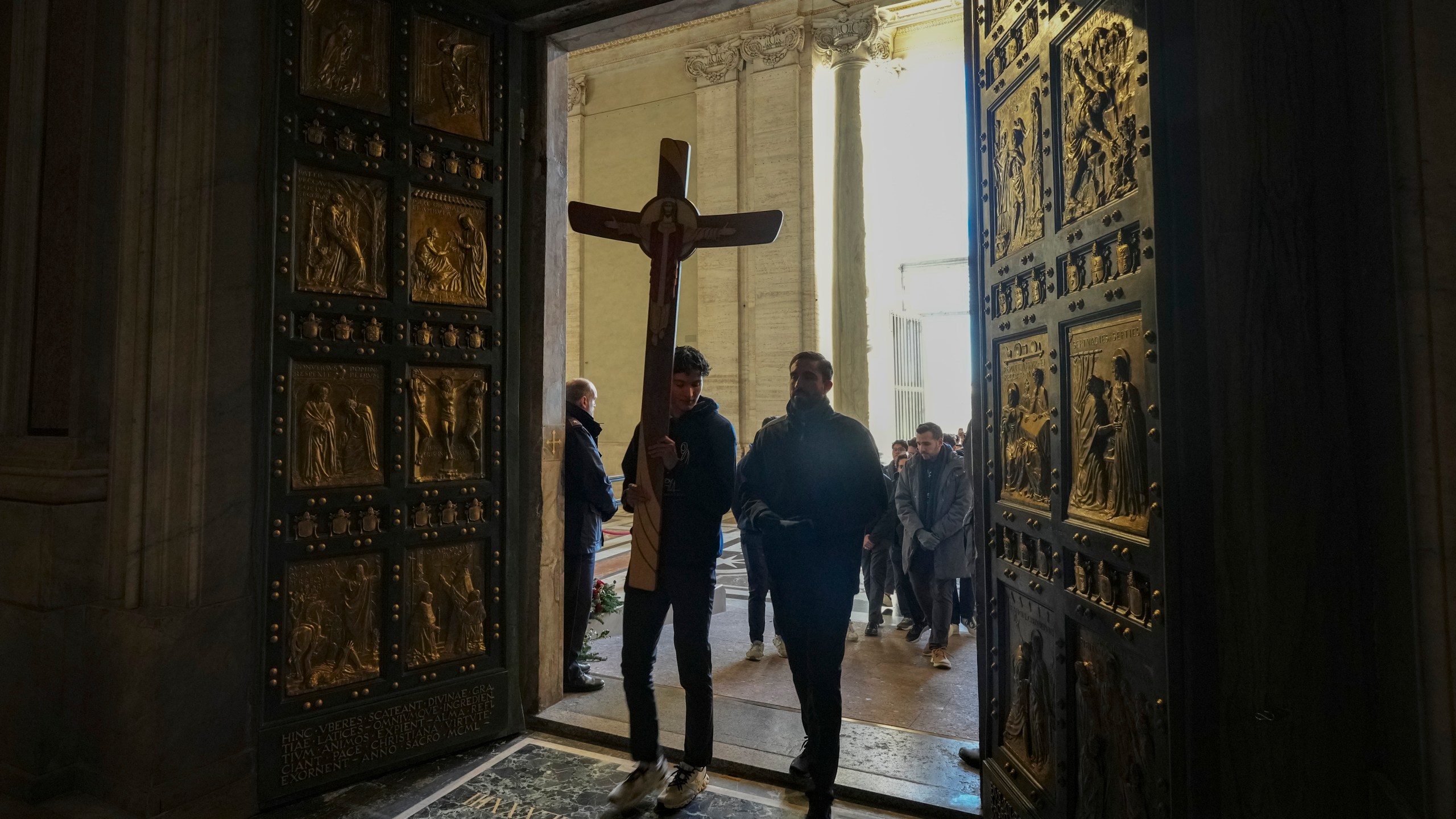 Faithful walk through the Holy Door of St.Peter's Basilica at the Vatican, Wednesday, Dec. 25, 2024, after it was opened by Pope Francis on Christmas Eve marking the start of the Catholic 2025 Jubilee. (AP Photo/Andrew Medichini)