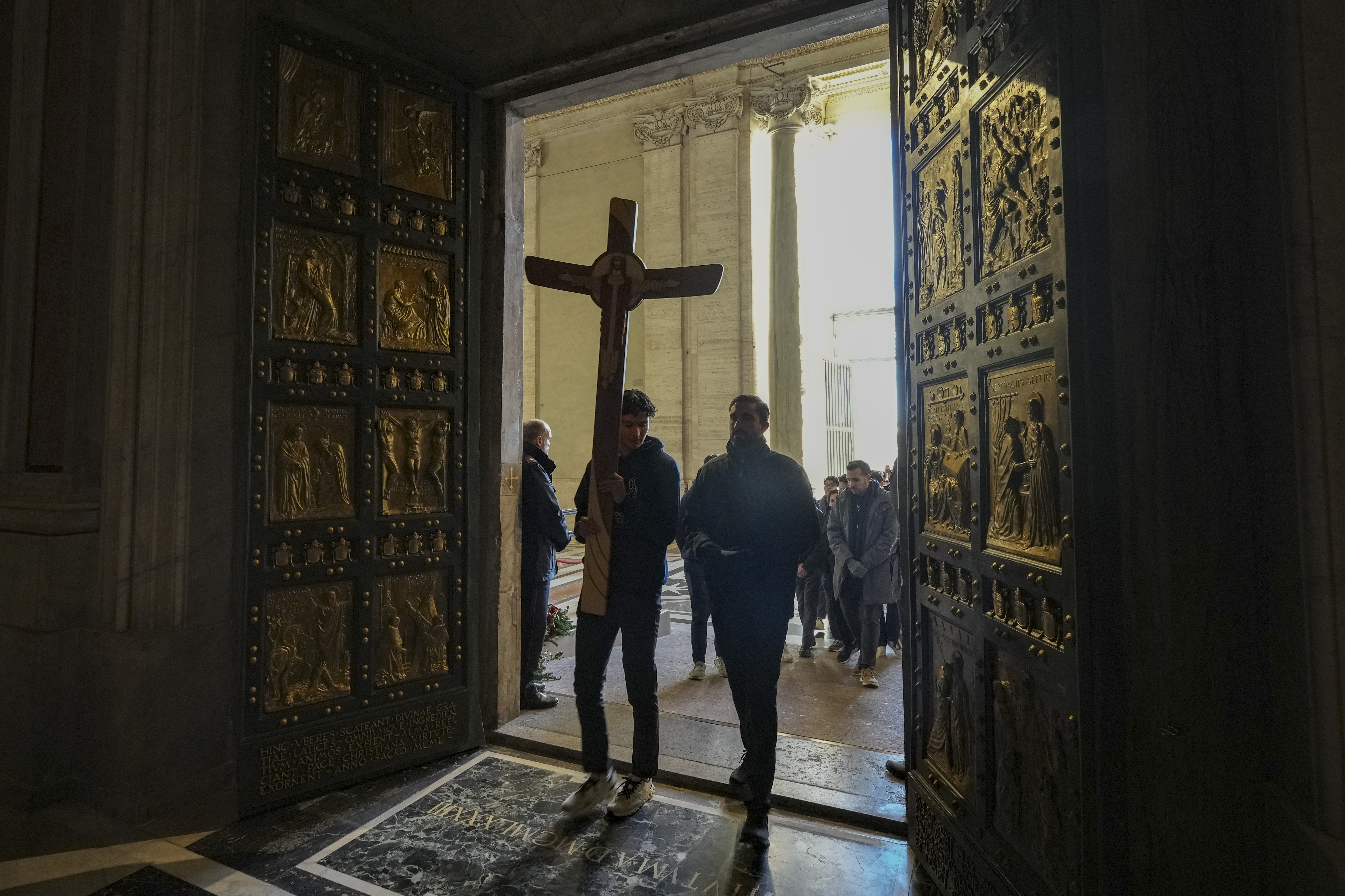 Faithful walk through the Holy Door of St.Peter's Basilica at the Vatican, Wednesday, Dec. 25, 2024, after it was opened by Pope Francis on Christmas Eve marking the start of the Catholic 2025 Jubilee. (AP Photo/Andrew Medichini)