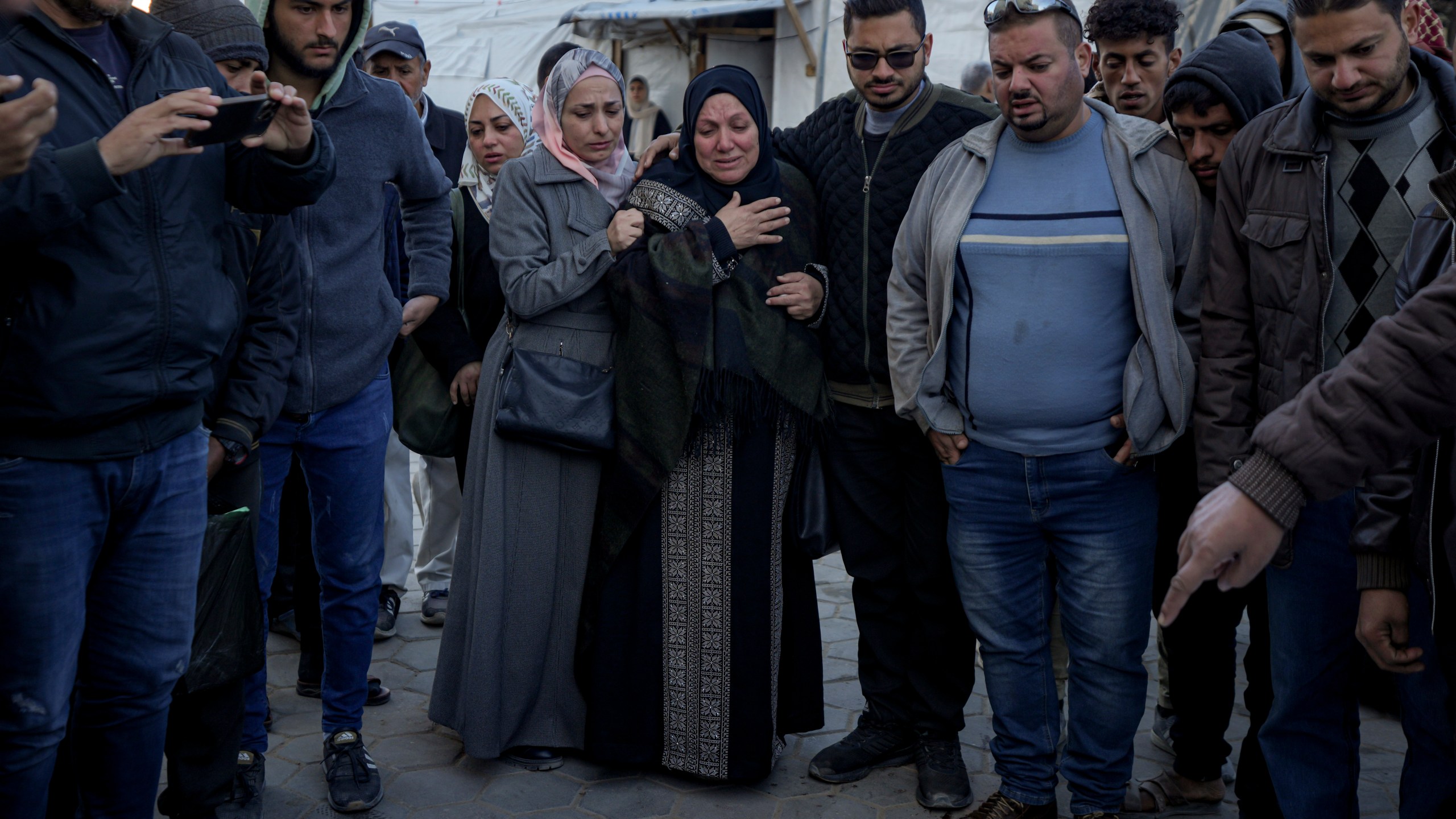 Palestinians react next to the bodies of their relatives who were killed in the Israeli bombardment of the Gaza Strip at Al-Aqsa Hospital in Deir Al-Balah, Wednesday, Dec. 25, 2024. (AP Photo/Abdel Kareem Hana)