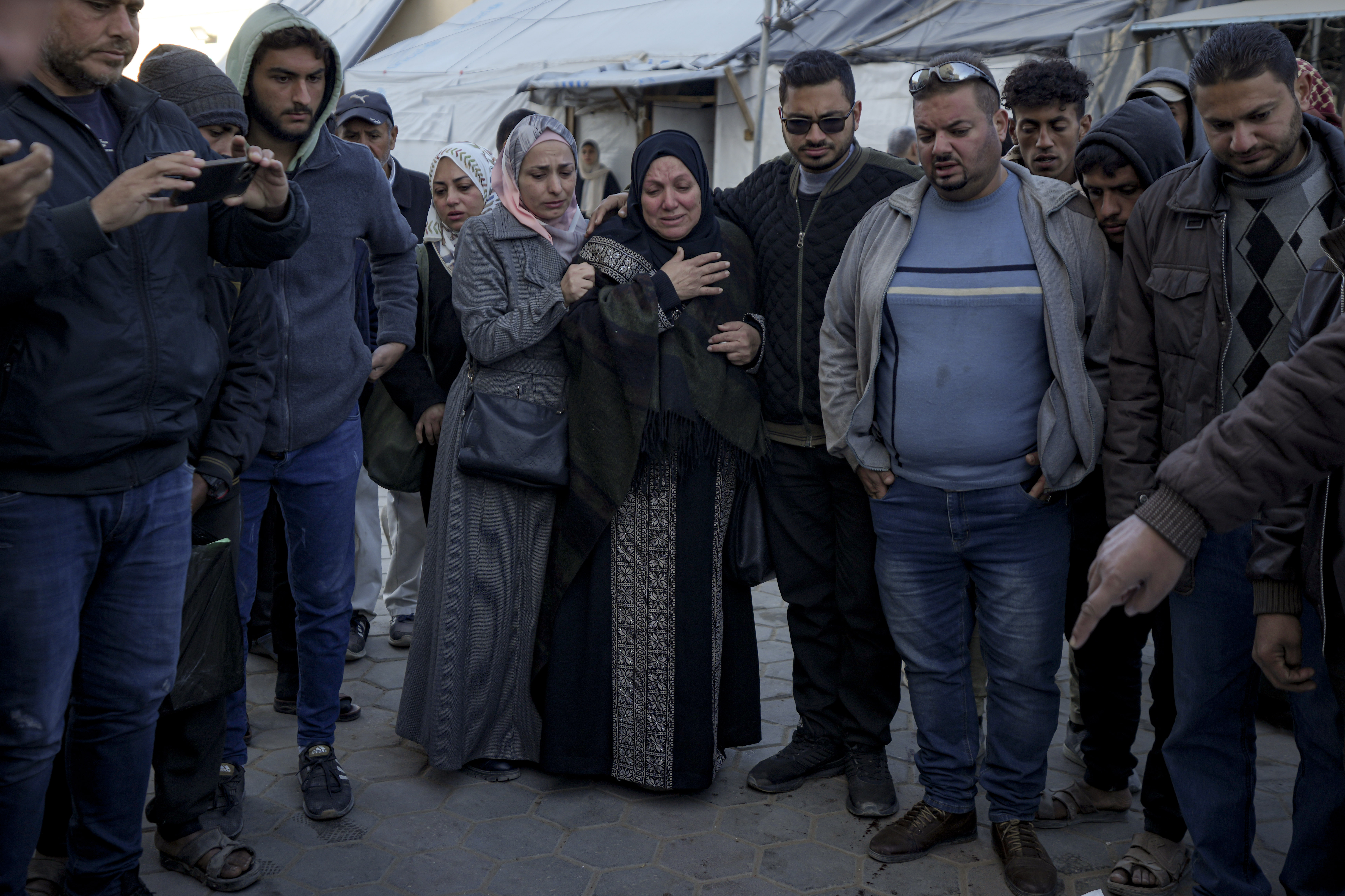 Palestinians react next to the bodies of their relatives who were killed in the Israeli bombardment of the Gaza Strip at Al-Aqsa Hospital in Deir Al-Balah, Wednesday, Dec. 25, 2024. (AP Photo/Abdel Kareem Hana)