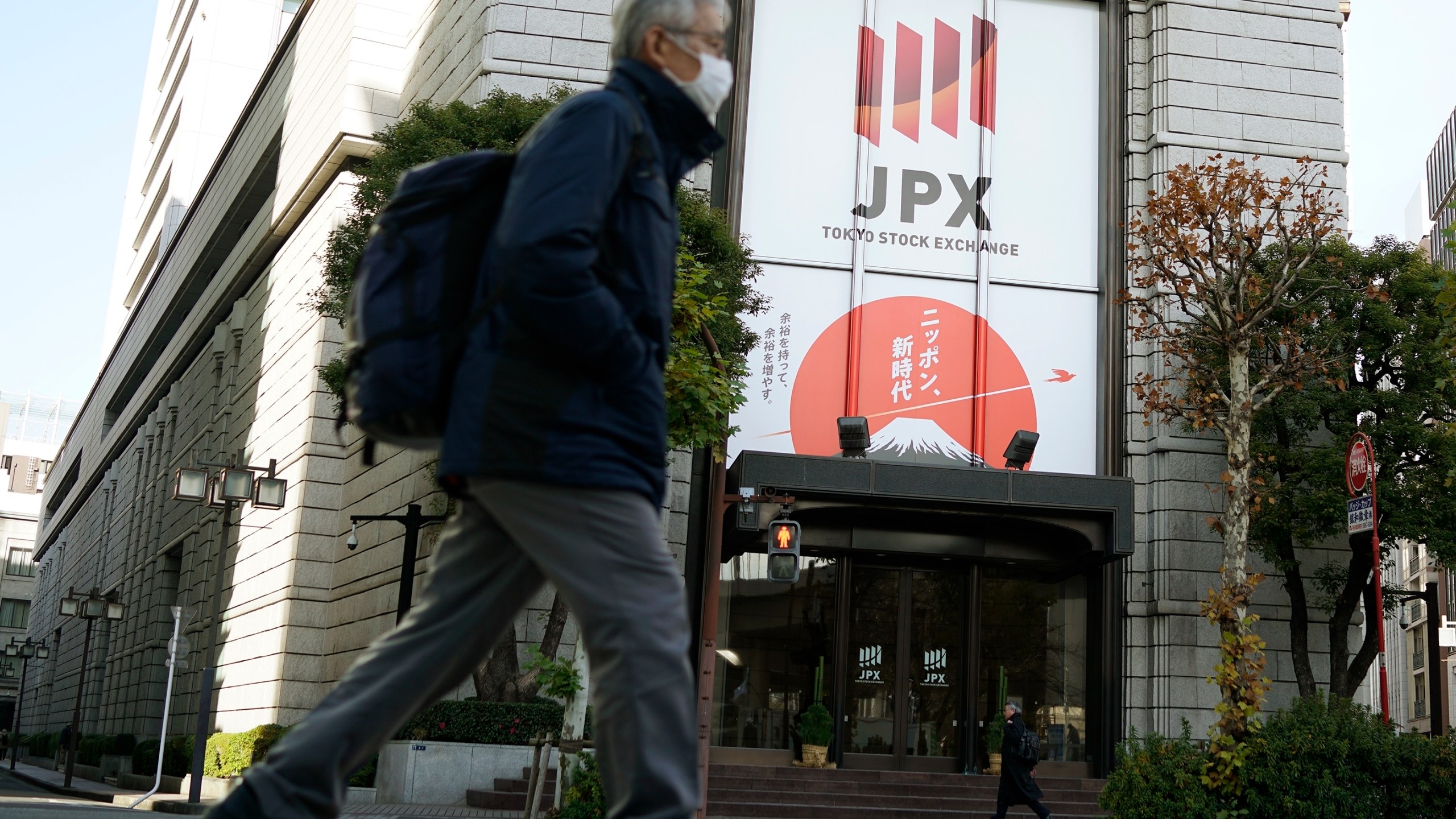 People walk in front of Tokyo Stock Exchange building Wednesday, Dec. 25, 2024, in Tokyo. (AP Photo/Eugene Hoshiko)