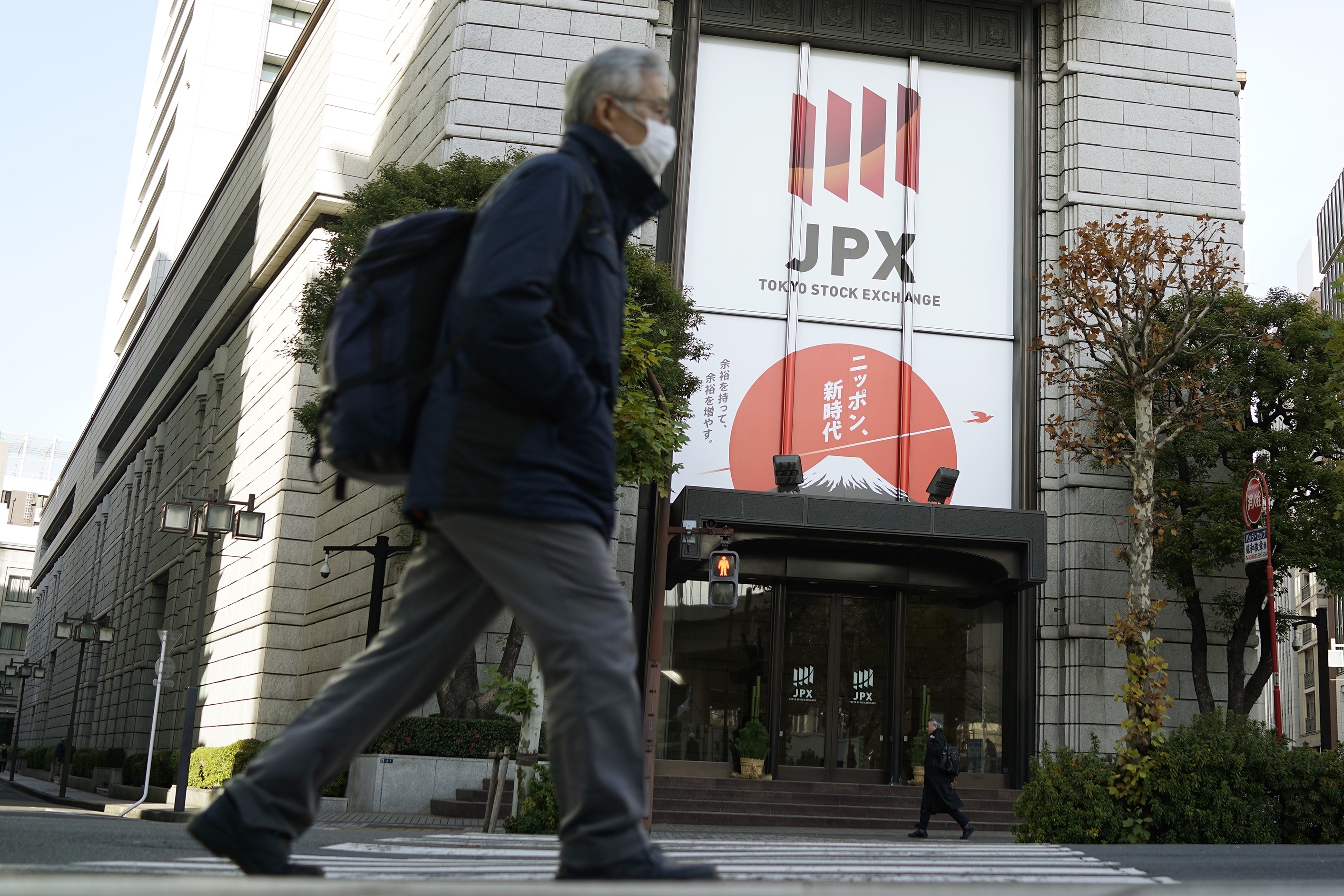 People walk in front of Tokyo Stock Exchange building Wednesday, Dec. 25, 2024, in Tokyo. (AP Photo/Eugene Hoshiko)