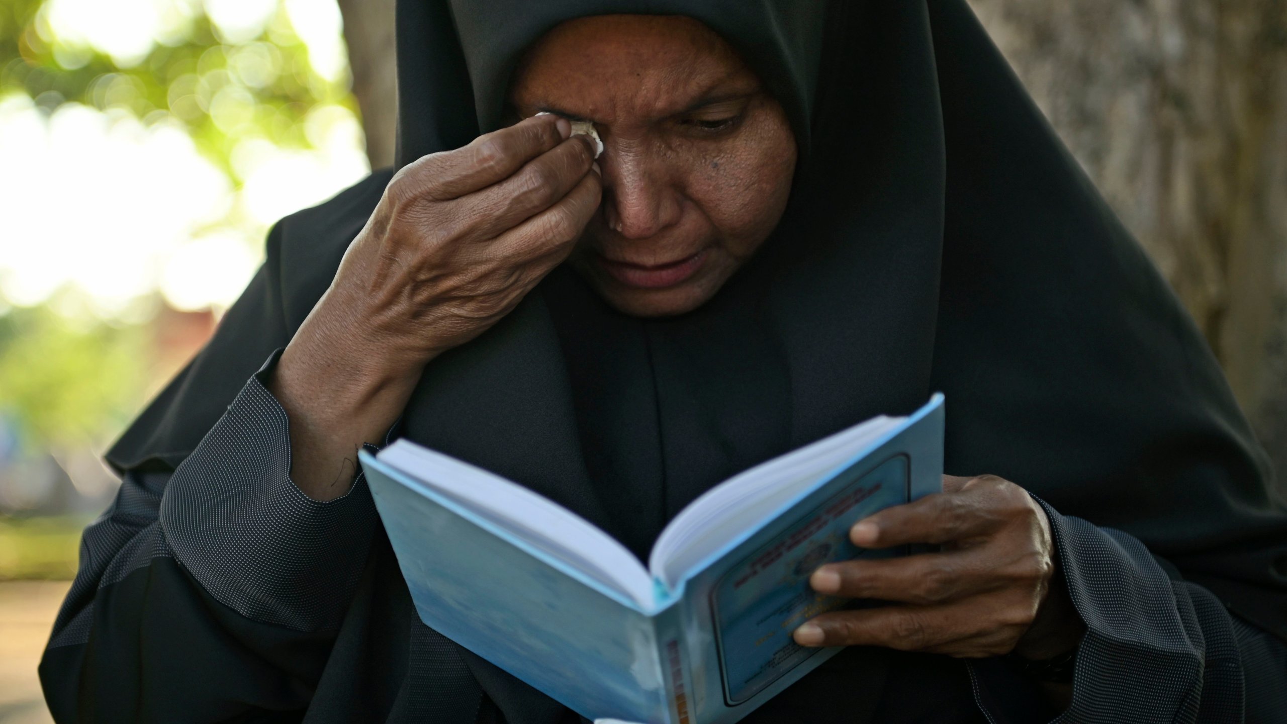 A woman weeps as she prays at a mass grave at victims of the 2004 Indian Ocean tsunami, in Banda Aceh, Indonesia, Thursday, Dec. 26, 2024. (AP Photo/Reza Saifullah)