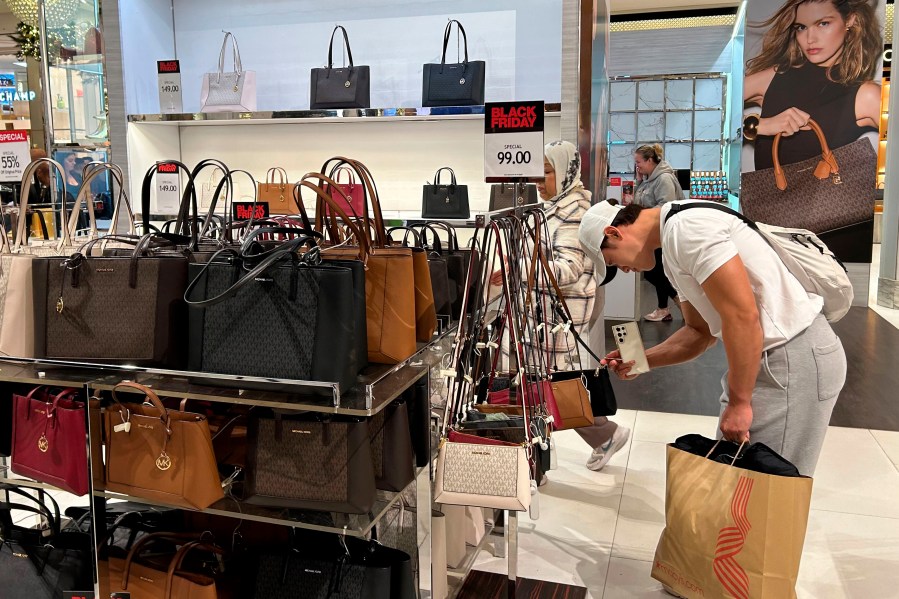 FILE - A shopper looks at handbags at Macy's department store on Sunday, Nov. 24, 2024, in New York. (AP Photo/Anne D'Innocenzio, File)