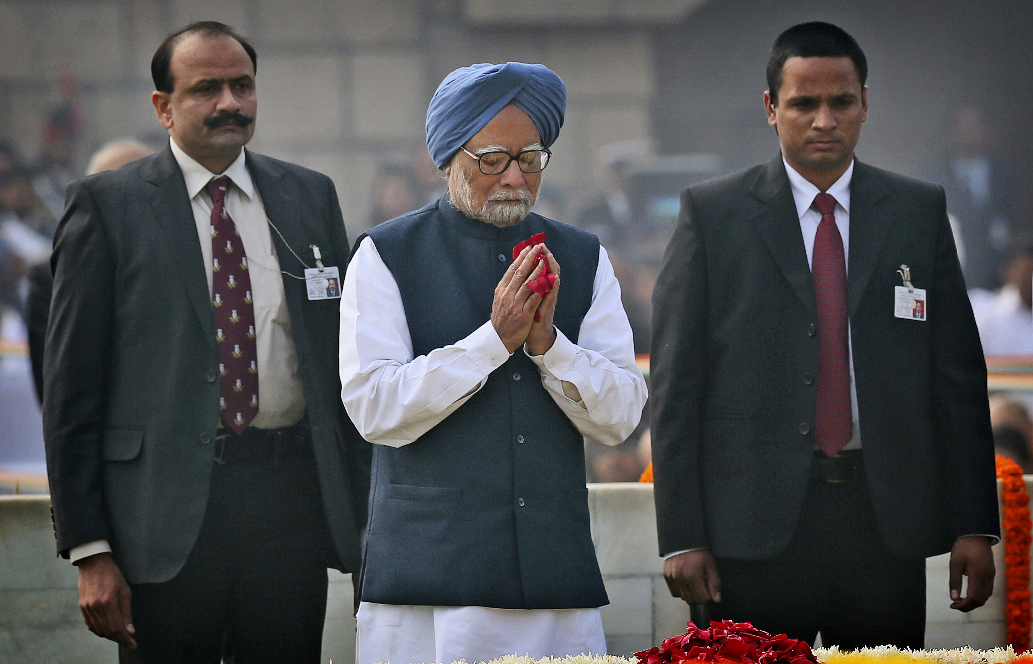 FILE - Indian Prime Minister Manmohan Singh, center, pays floral tributes at Rajghat, the memorial of Mahatma Gandhi, on his death anniversary in New Delhi, India, Monday, Jan. 30, 2014. (AP Photo/Manish Swarup, File)