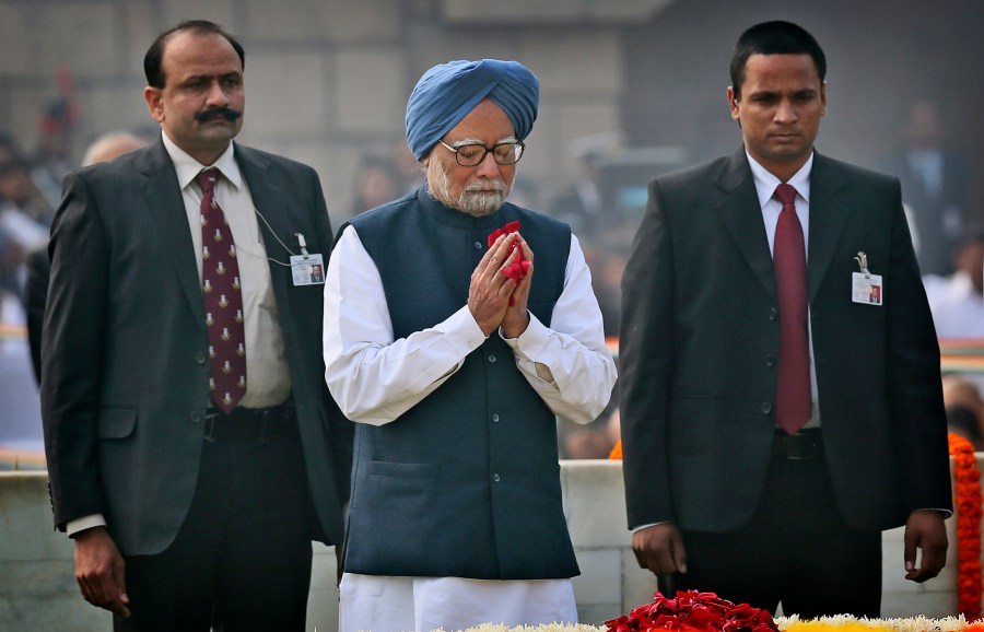 FILE - Indian Prime Minister Manmohan Singh, center, pays floral tributes at Rajghat, the memorial of Mahatma Gandhi, on his death anniversary in New Delhi, India, Monday, Jan. 30, 2014. (AP Photo/Manish Swarup, File)