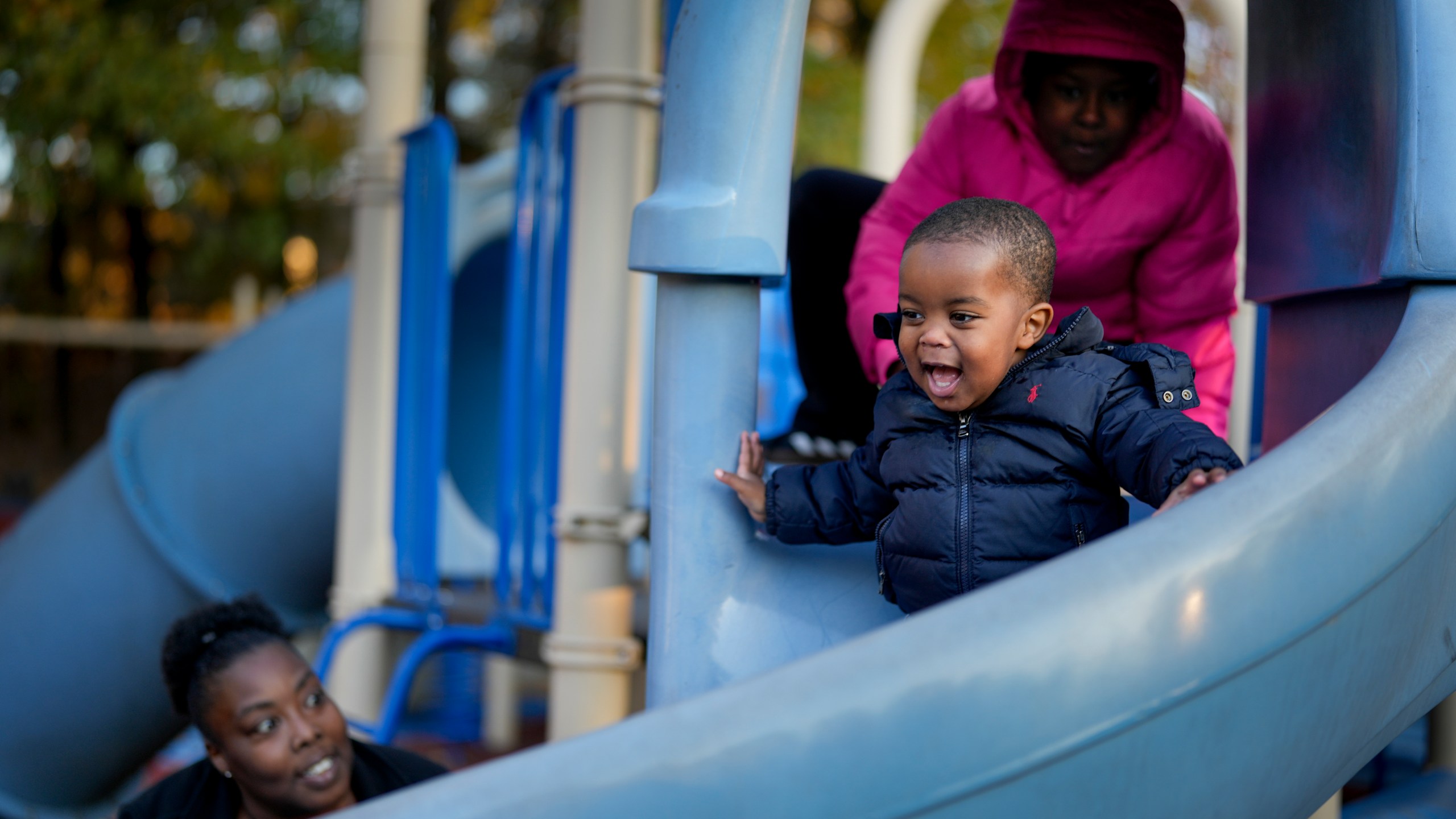 Anika Chillis, left, spends time with her children, Makhi, 2, center, and Myla 9, right, at a playground Monday, Dec. 2, 2024, in Memphis, Tenn. (AP Photo/George Walker IV)