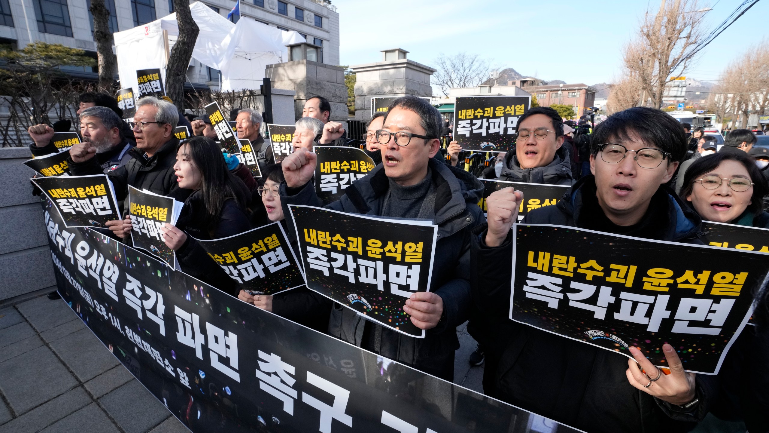 Protesters stage a rally demanding the arrest of impeached South Korean President Yoon Suk Yeol outside of the Constitutional Court in Seoul, South Korea, Friday, Dec. 27, 2024. The signs read, "Fire the rebellion leader Yoon Suk Yeol immediately." (AP Photo/Ahn Young-joon)