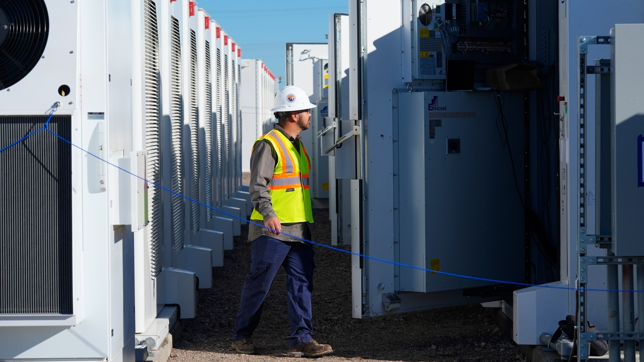 FILE - A worker does checks on battery storage pods at Orsted's Eleven Mile Solar Center lithium-ion battery storage energy facility, Feb. 29, 2024, in Coolidge, Ariz. (AP Photo/Ross D. Franklin, File)