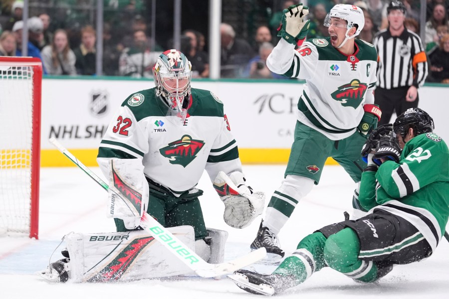 Dallas Stars left wing Mason Marchment (27) falls to ice as Minnesota Wild defenseman Jared Spurgeon (46) calls for an end to play after Marchment was hit by a puck in front of Wild goaltender Filip Gustavsson (32) during the first period of an NHL hockey game Friday, Dec. 27, 2024, in Dallas. (AP Photo/LM Otero)