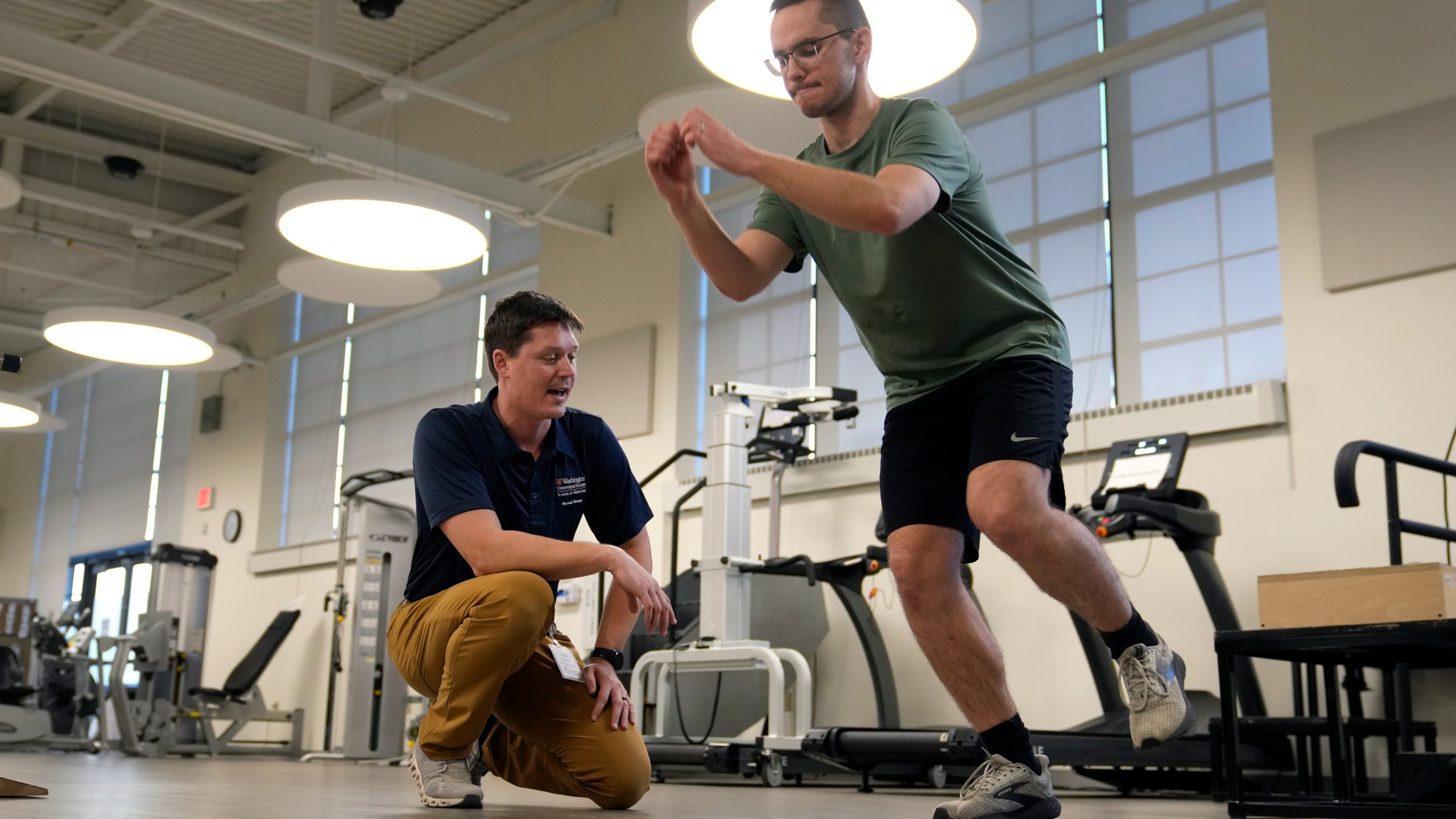 Physical therapist Tyler Detmer, left, works with patient Jacob Bullard at WashU, Monday, Dec. 16, 2024, in St. Louis. (AP Photo/Jeff Roberson)