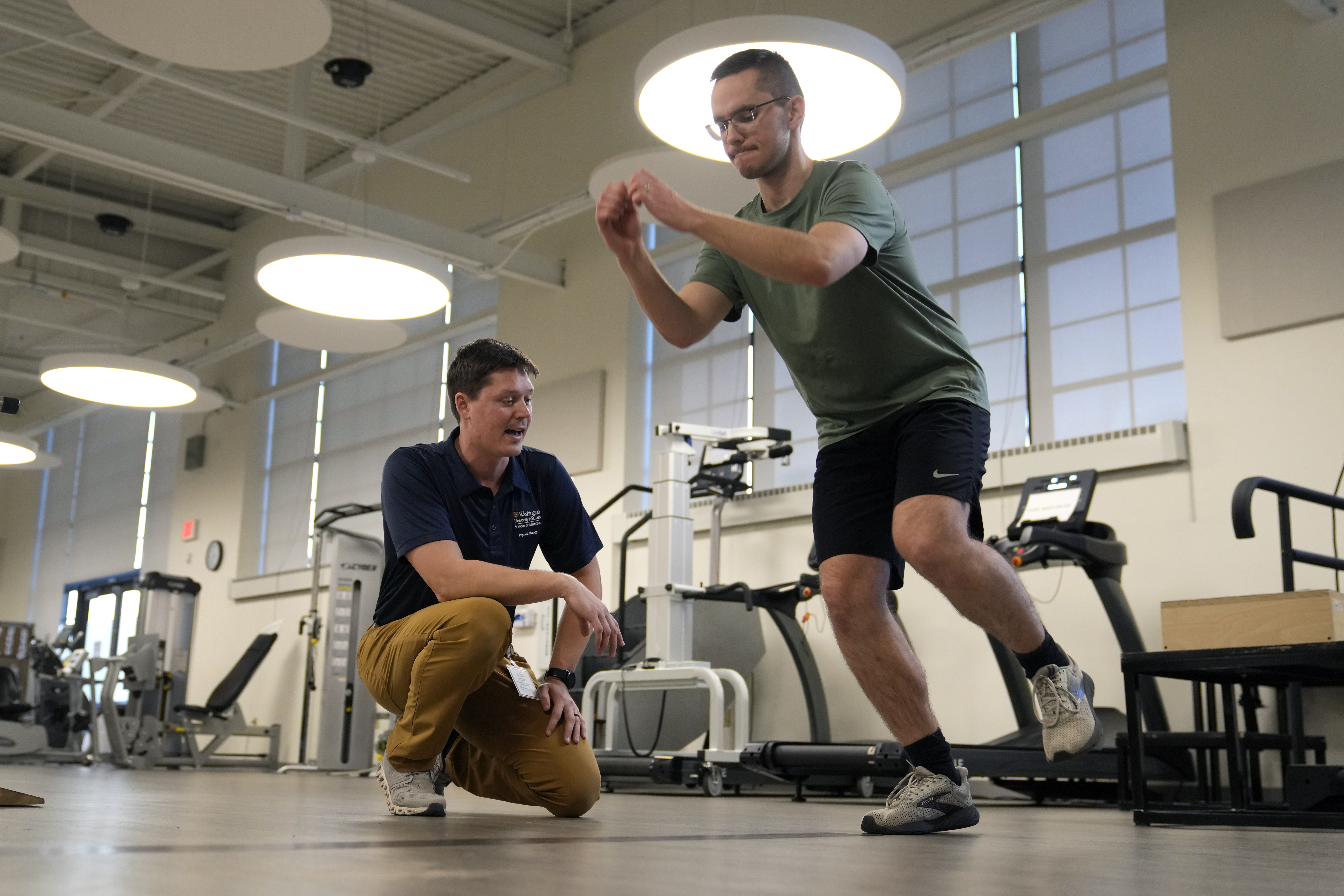 Physical therapist Tyler Detmer, left, works with patient Jacob Bullard at WashU, Monday, Dec. 16, 2024, in St. Louis. (AP Photo/Jeff Roberson)