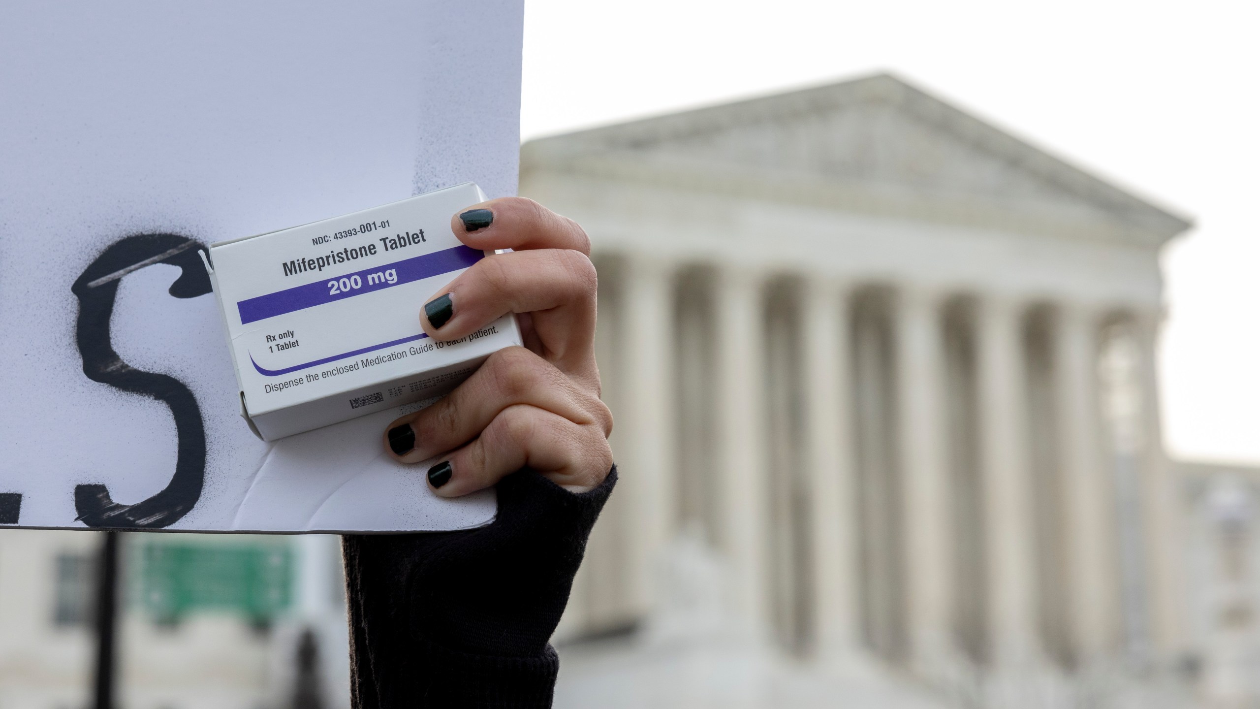 FILE - An abortion- rights activist holds a box of mifepristone pills as demonstrators from both anti-abortion and abortion-rights groups rally outside the Supreme Court in Washington, Tuesday, March 26, 2024. (AP Photo/Amanda Andrade-Rhoades, File)