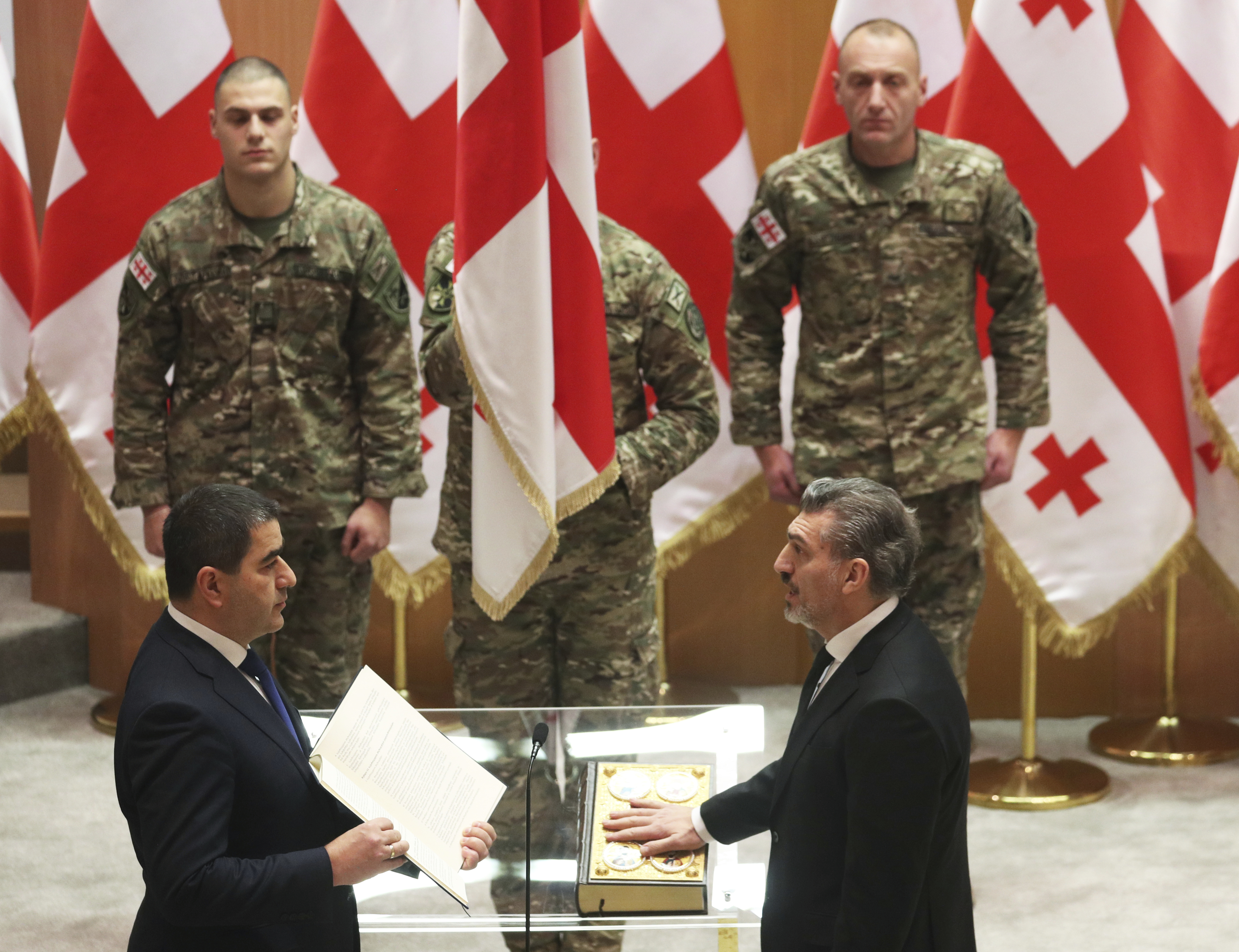 Georgian President-elect Mikheil Kavelashvili, right, takes the oath during his swearing-in ceremony at the Georgian parliament in Tbilisi, Georgia, Sunday, Dec. 29, 2024. (Irakli Gedenidze/Pool Photo via AP)