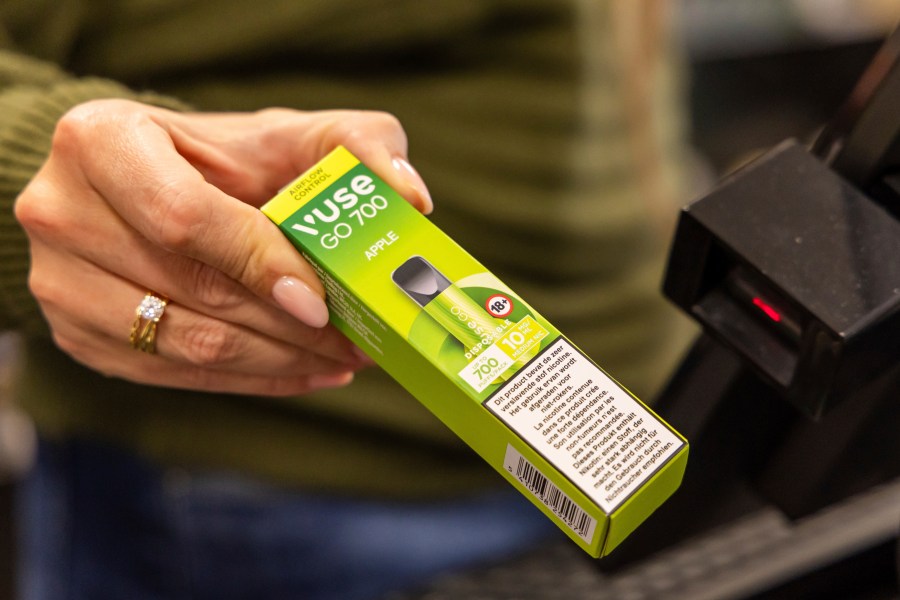 A storekeeper moves a disposable electronic cigarette device past a price scanner at a shop in Brussels on Dec. 12, 2024, ahead of Belgium's ban on the sale of disposable vapes as of Jan. 1, 2025. (AP Photo/Geert Vanden Wijngaert)