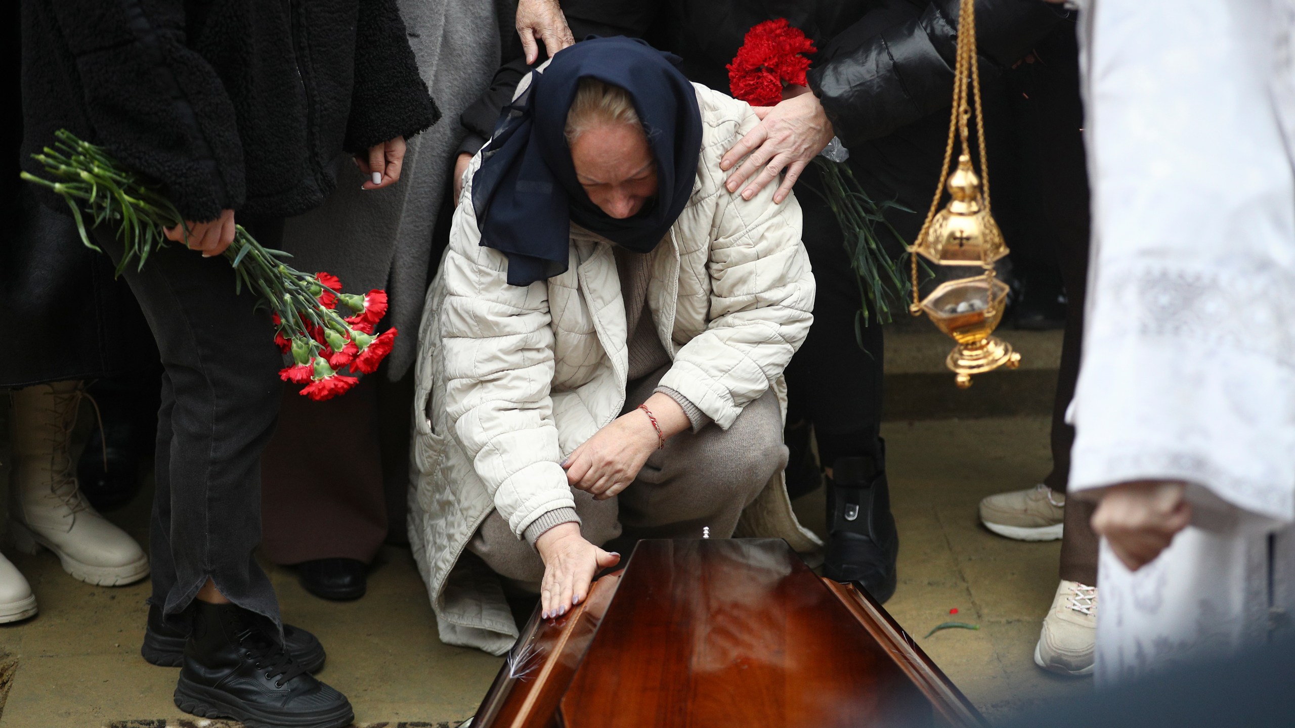 Yana Kshnyakina, widow of pilot in command Igor Kshnyakin mourns at the coffin during a funeral of crew members of the Azerbaijan Airlines Embraer 190 killed in a deadly plane crash in Kazakhstan this week, at the II Alley of Honor in Baku, Azerbaijan, Sunday, Dec. 29, 2024. (AP photo)