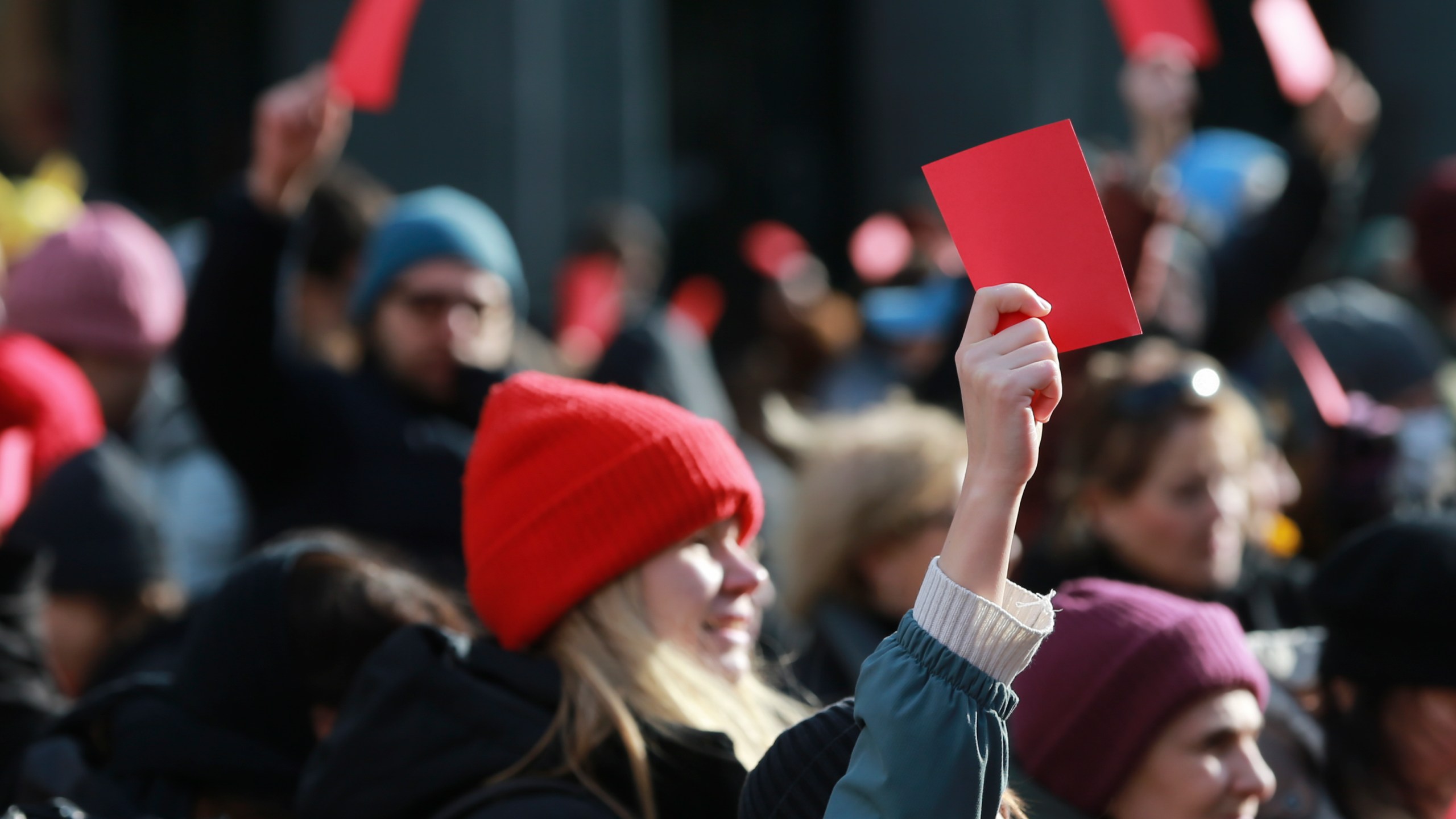 Demonstrators hold red cards outside of the Georgian parliament where the President-elect Mikheil Kavelashvili, a former soccer player, takes his oath at the swearing-in ceremony, in Tbilisi, Georgia, Sunday, Dec. 29, 2024. (AP Photo/Zurab Tsertsvadze)