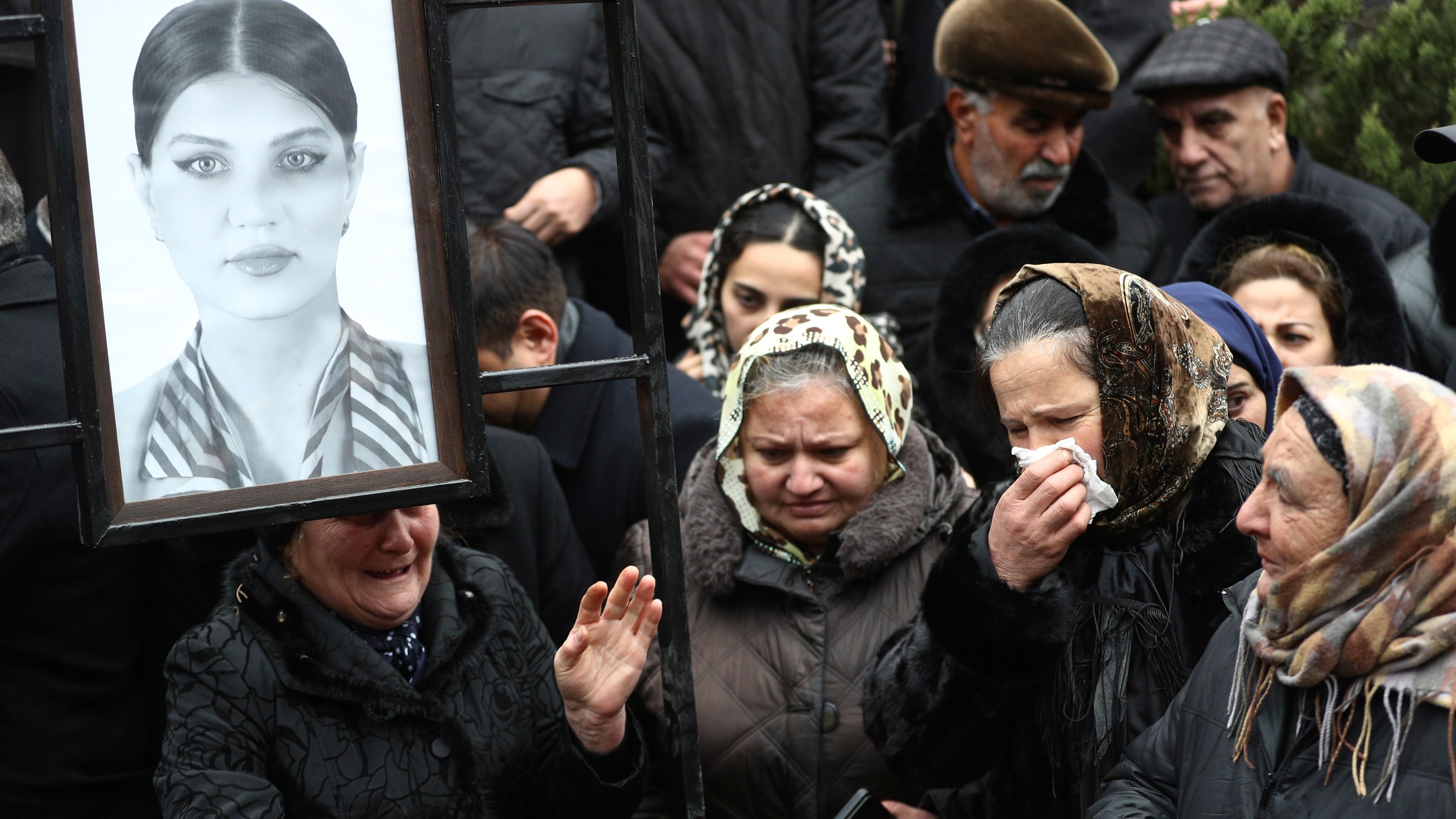 People mourn at the grave of flight attendant Hokume Aliyeva during a funeral of the crew members of the Azerbaijan Airlines Embraer 190 killed in a deadly plane crash in Kazakhstan this week, at the II Alley of Honor in Baku, Azerbaijan, Sunday, Dec. 29, 2024. (AP photo)