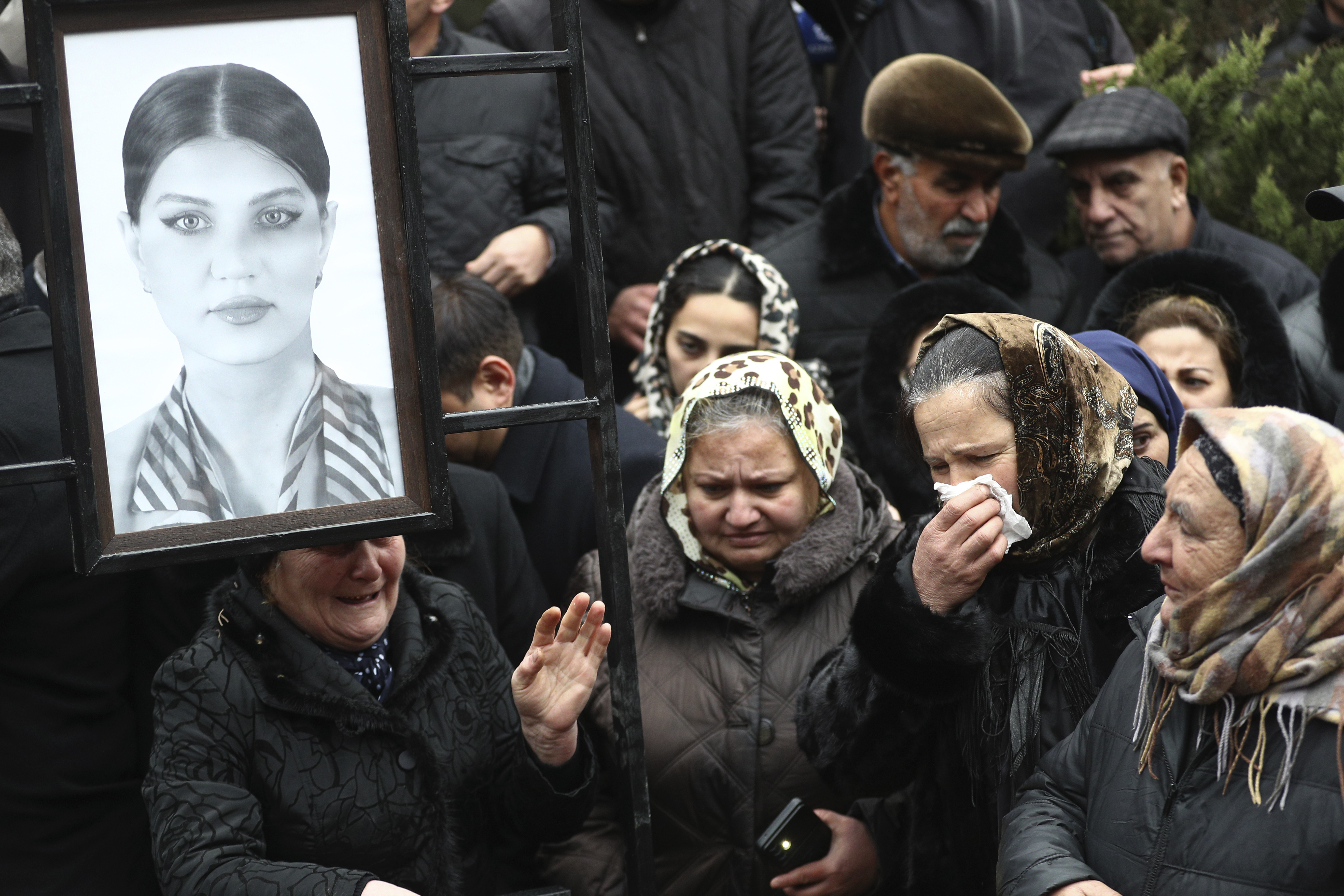 People mourn at the grave of flight attendant Hokume Aliyeva during a funeral of the crew members of the Azerbaijan Airlines Embraer 190 killed in a deadly plane crash in Kazakhstan this week, at the II Alley of Honor in Baku, Azerbaijan, Sunday, Dec. 29, 2024. (AP photo)