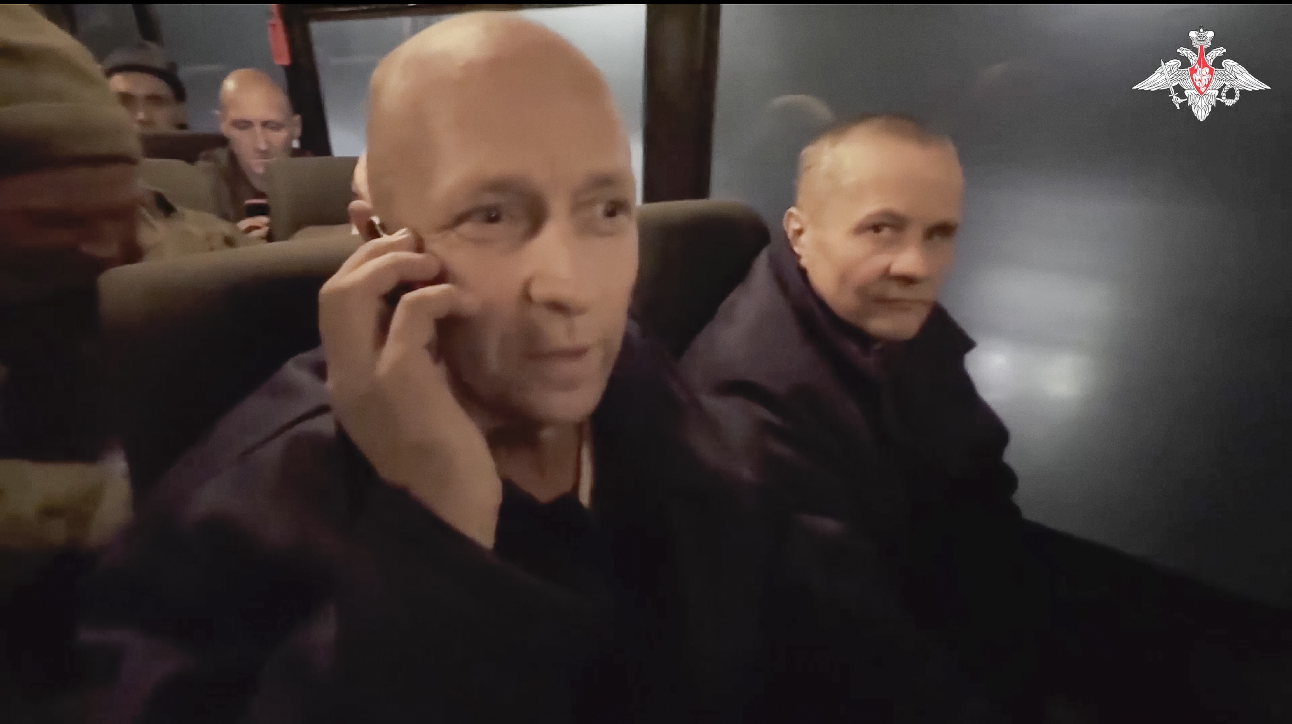 In this photo taken from video released by the Russian Defense Ministry Press Service on Monday, Dec. 30, 2024, a Russian soldier speaks on the phone with his relatives as he and others sit in a bus after being released in a prisoners swap between Russia and Ukraine, at an unspecified location in Belarus. (Russian Defense Ministry Press Service via AP)