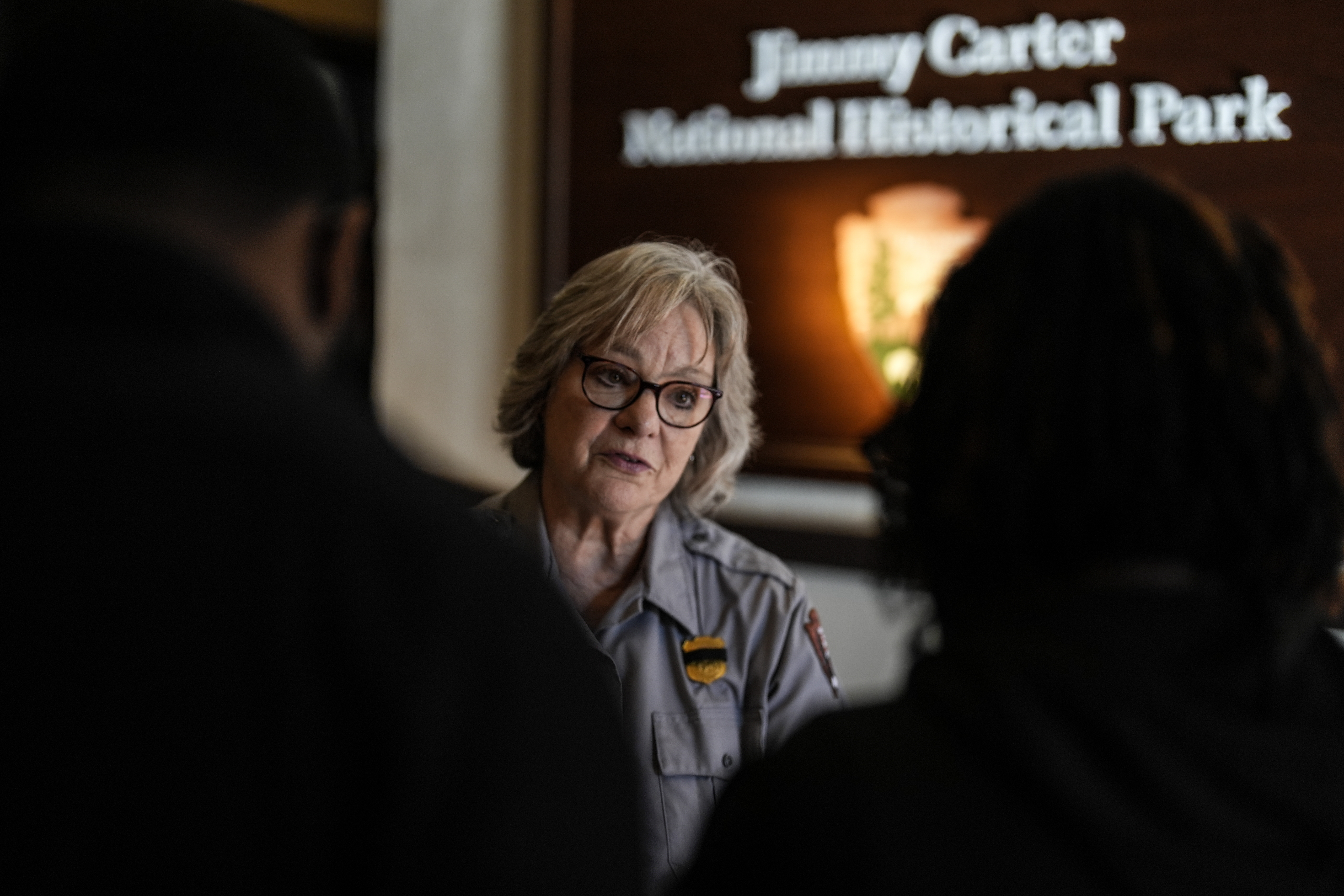 National Park employee Mary Anne Robbins speaks to guests of the Jimmy Carter National Historical Park, Monday, Dec. 30, 2024, in Plains, Ga. Former President Carter died Sunday at the age of 100. (AP Photo/Mike Stewart)