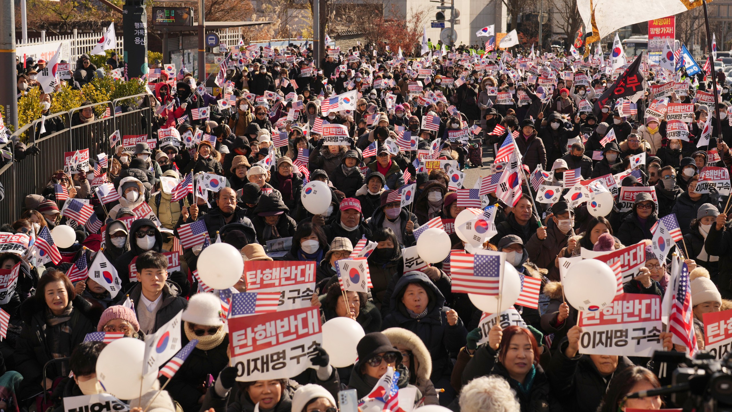 Supporters of impeached South Korean President Yoon Suk Yeol stage a rally near the presidential residence in Seoul, South Korea, Tuesday, Dec. 31, 2024. The letters read "Oppose Impeachment," and "Arrest Lee Jae-myung." (AP Photo/Lee Jin-man)