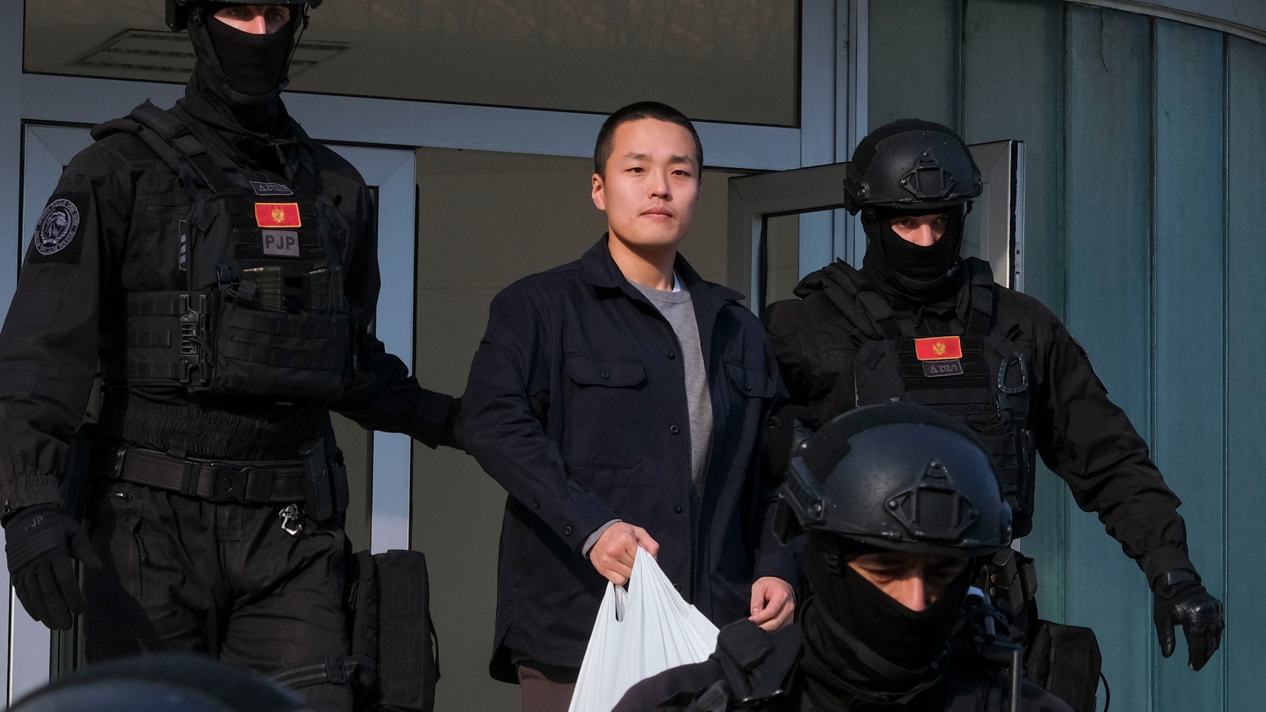 FILE - Montenegrin police officers escort South Korean citizen, Terraform Labs founder Do Kwon in Montenegro's capital Podgorica, Saturday, March 23, 2024. (AP Photo/Risto Bozovic, File)