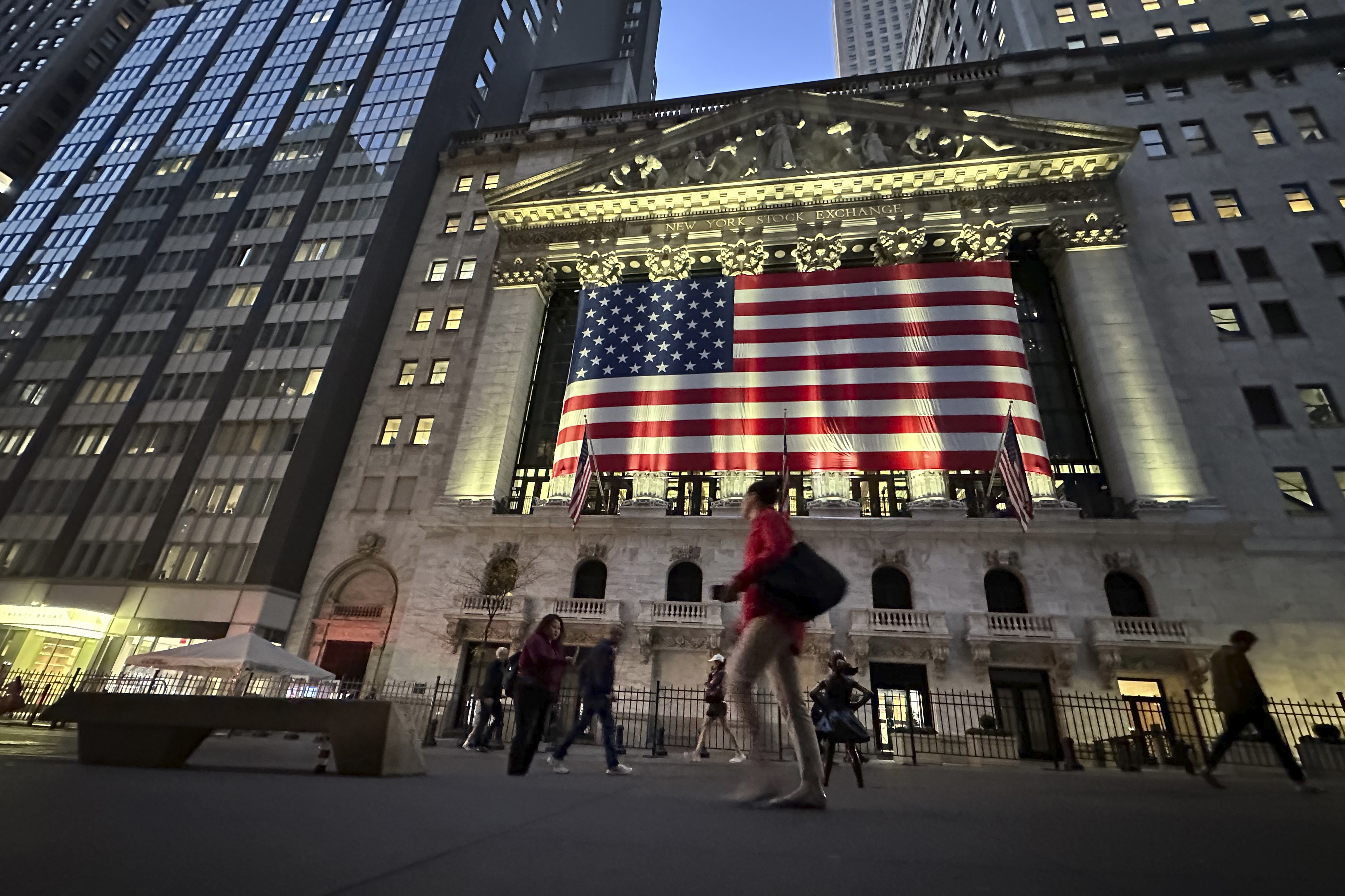 FILE - People pass the New York Stock Exchange on Nov. 5, 2024, in New York. (AP Photo/Peter Morgan, File)