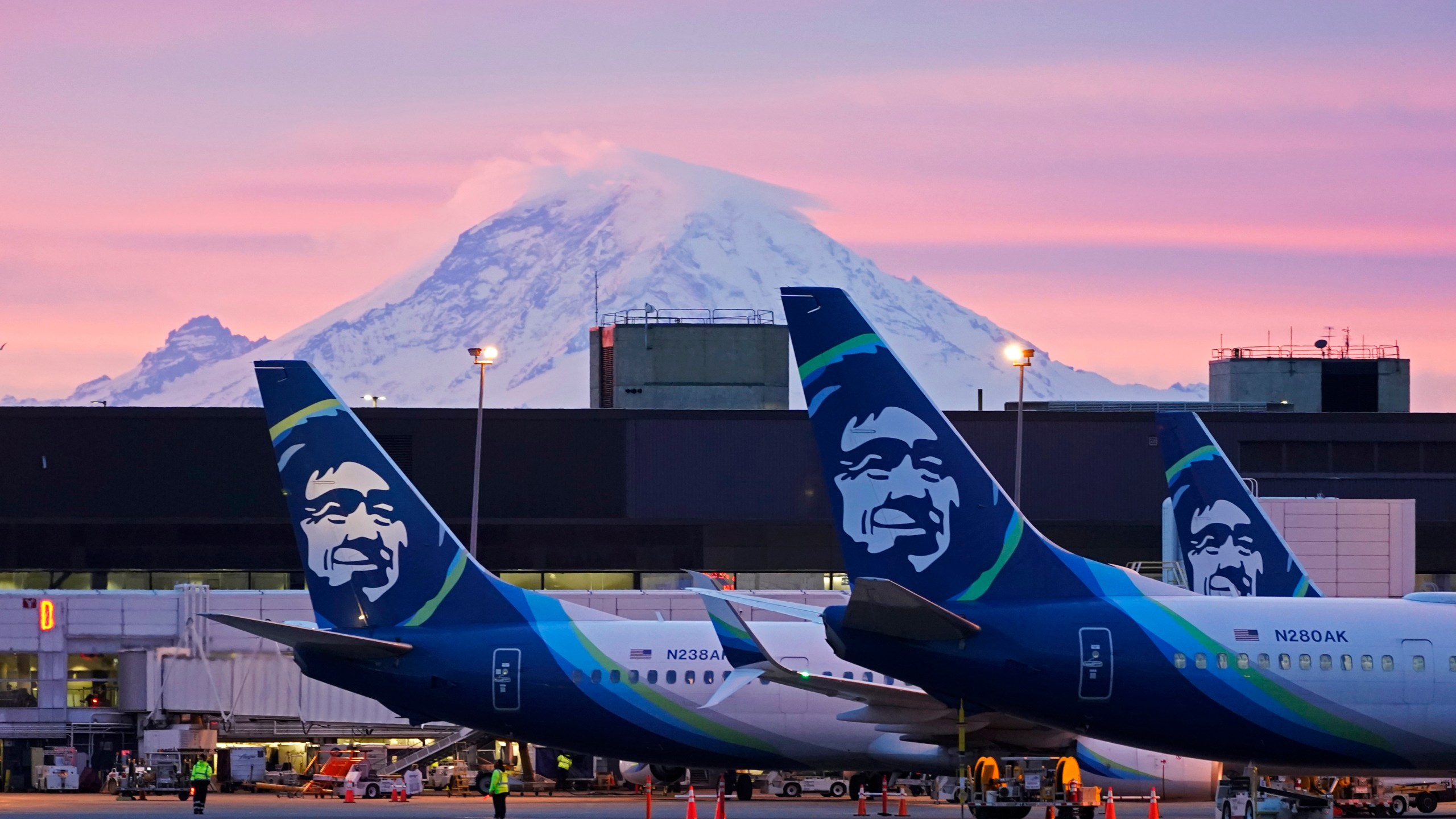 FILE - Alaska Airlines planes are shown parked at gates with Mount Rainier in the background at sunrise, March 1, 2021, at Seattle-Tacoma International Airport in Seattle. (AP Photo/Ted S. Warren, File)