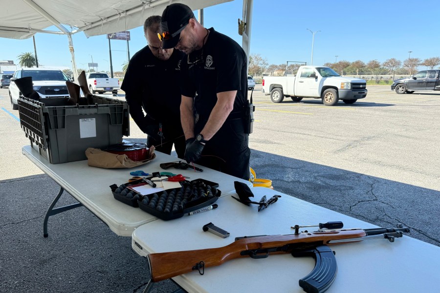 New Orleans police officers dismantle firearms handed over in exchange for PlayStations at a city-supported gun buyback Tuesday, Dec. 31, 2024, in New Orleans. (AP Photo/Jack Brook)