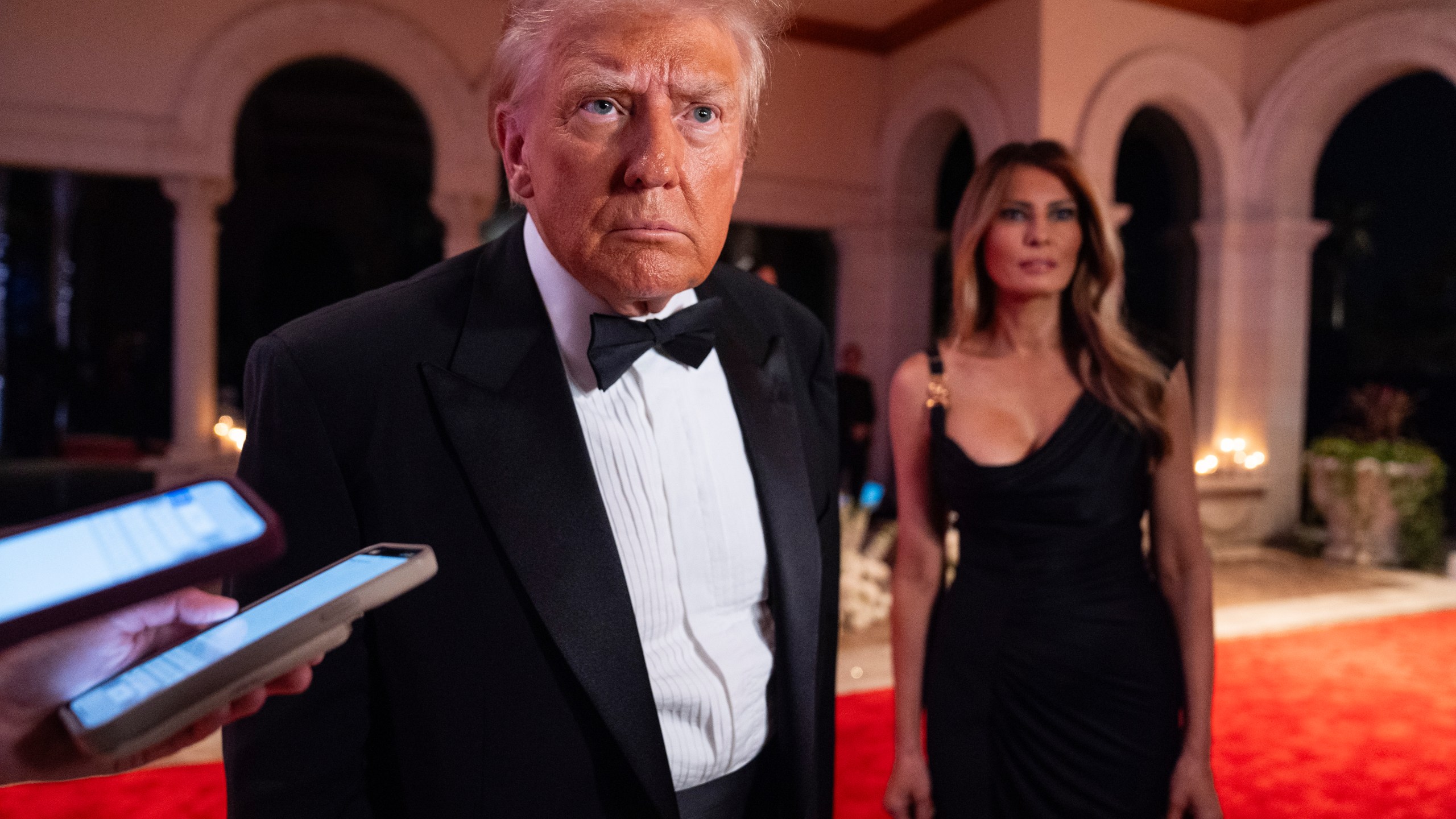 Melania Trump looks on as President-elect Donald Trump speaks to reporters before a New Year's Eve party at Mar-a-Lago, Tuesday, Dec. 31, 2024, in Palm Beach, Fla. (AP Photo/Evan Vucci)