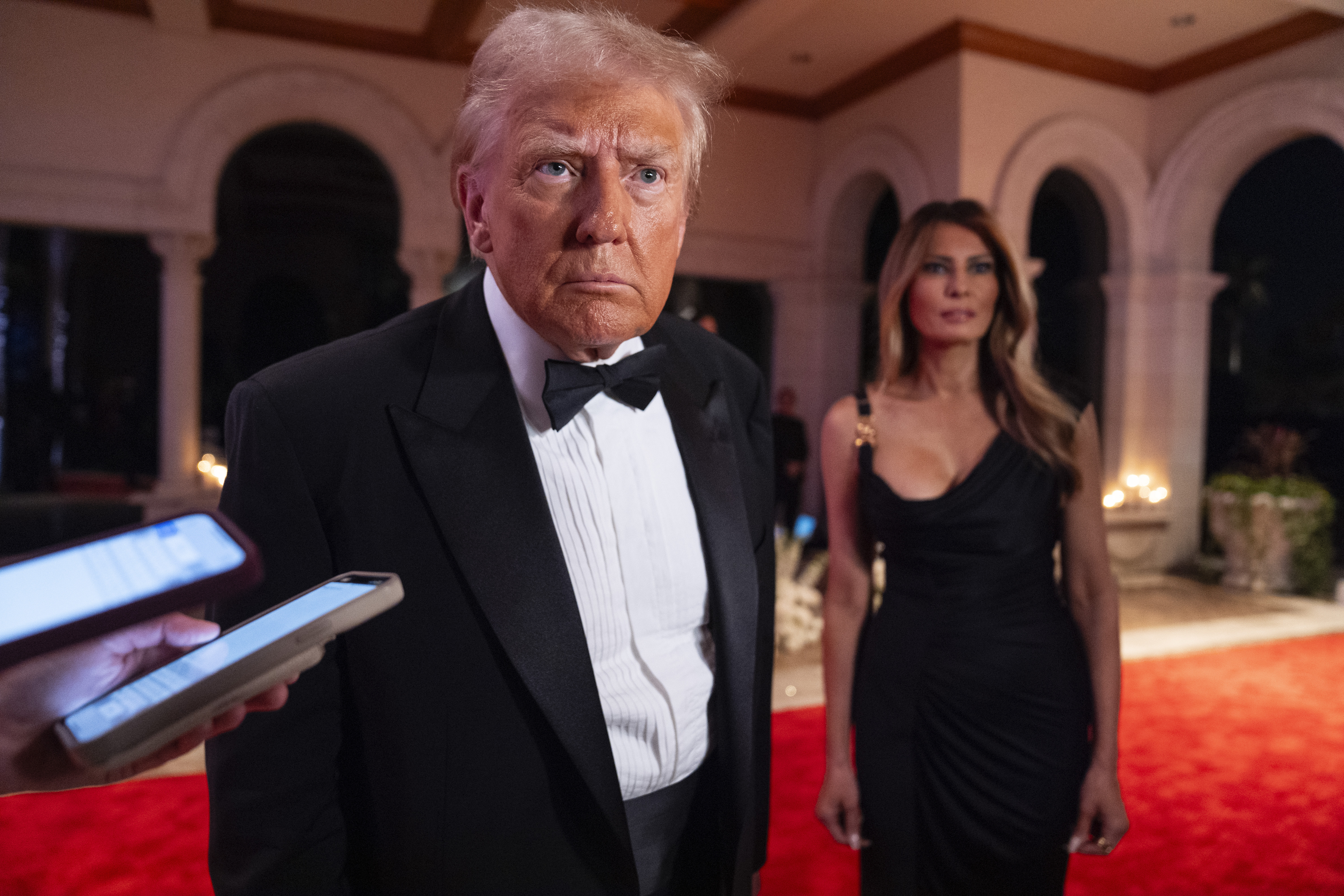 Melania Trump looks on as President-elect Donald Trump speaks to reporters before a New Year's Eve party at Mar-a-Lago, Tuesday, Dec. 31, 2024, in Palm Beach, Fla. (AP Photo/Evan Vucci)