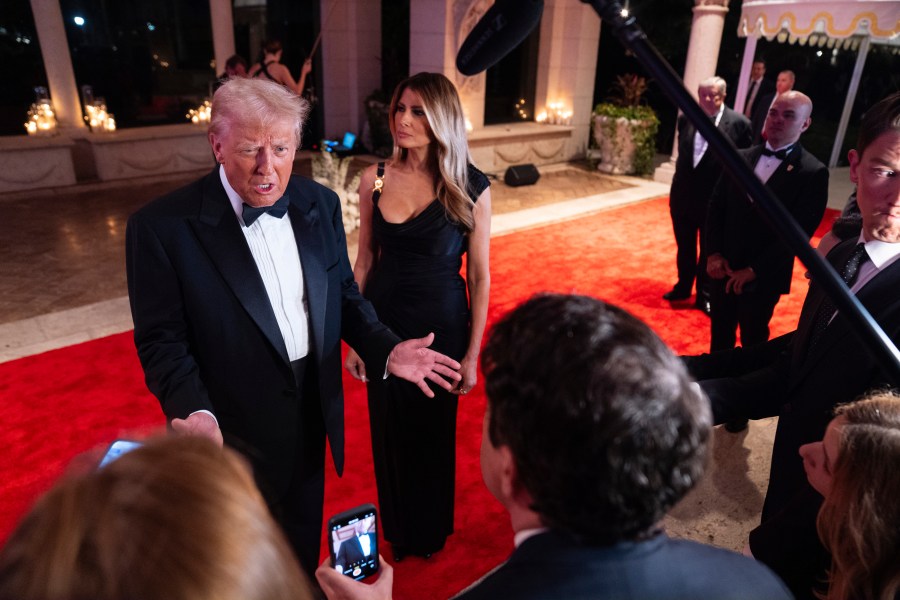 Melania Trump looks on as President-elect Donald Trump speaks to reporters before a New Year's Eve party at Mar-a-Lago, Tuesday, Dec. 31, 2024, in Palm Beach, Fla. (AP Photo/Evan Vucci)