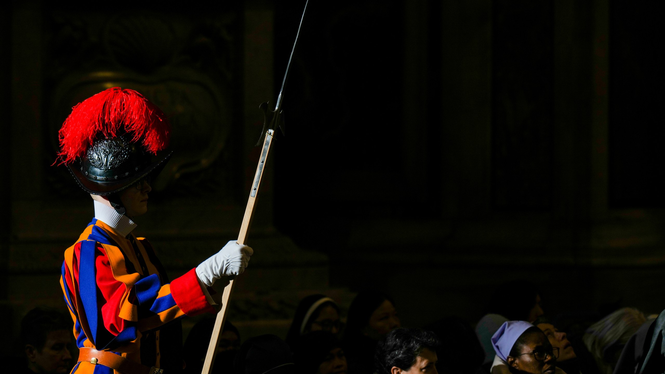 Faithful and a pontifical Swiss guard follow Pope Francis presiding over a mass in St. Peter's Basilica at The Vatican on New Year's Day, Wednesday, Jan. 1, 2025. (AP Photo/Andrew Medichini)