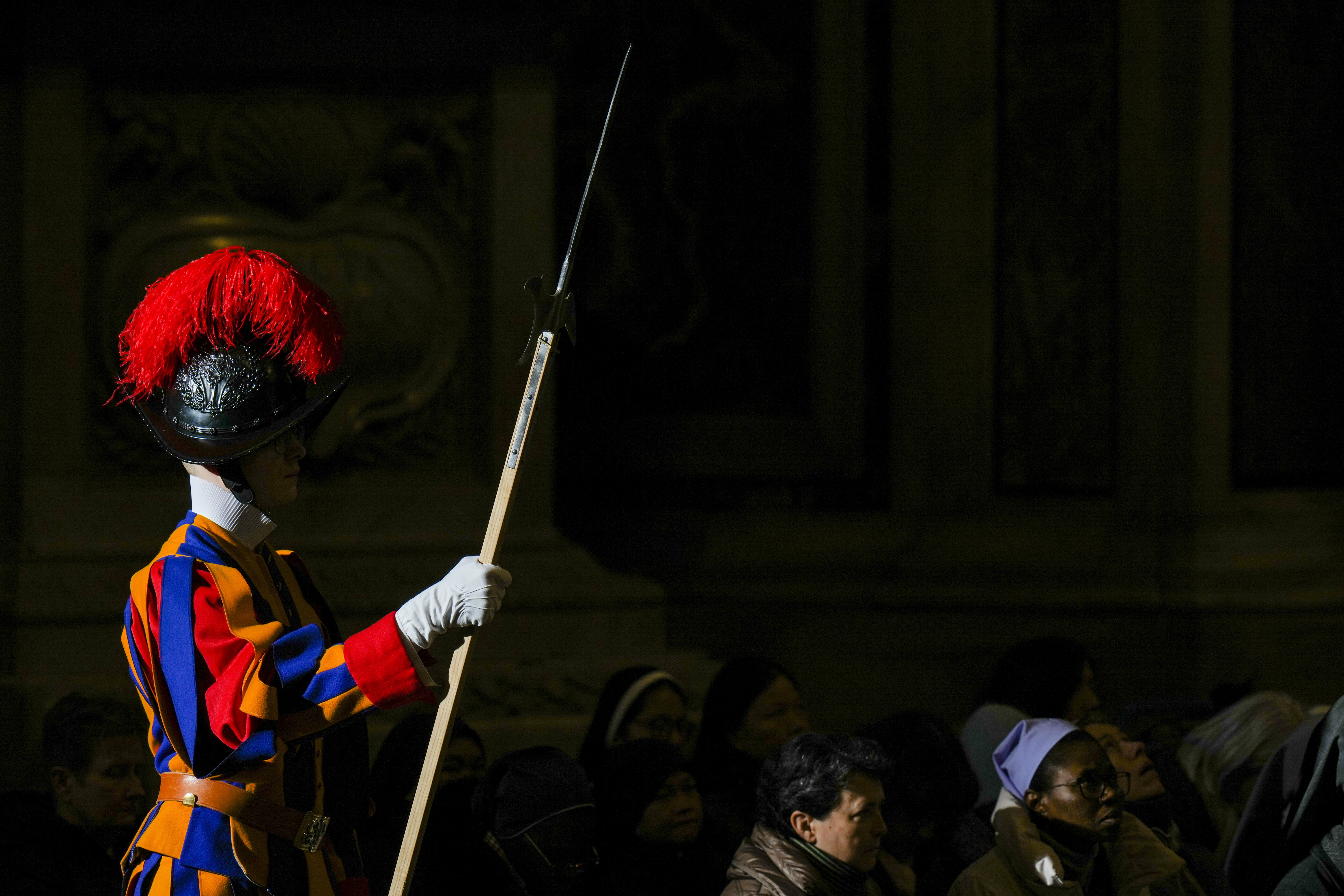 Faithful and a pontifical Swiss guard follow Pope Francis presiding over a mass in St. Peter's Basilica at The Vatican on New Year's Day, Wednesday, Jan. 1, 2025. (AP Photo/Andrew Medichini)