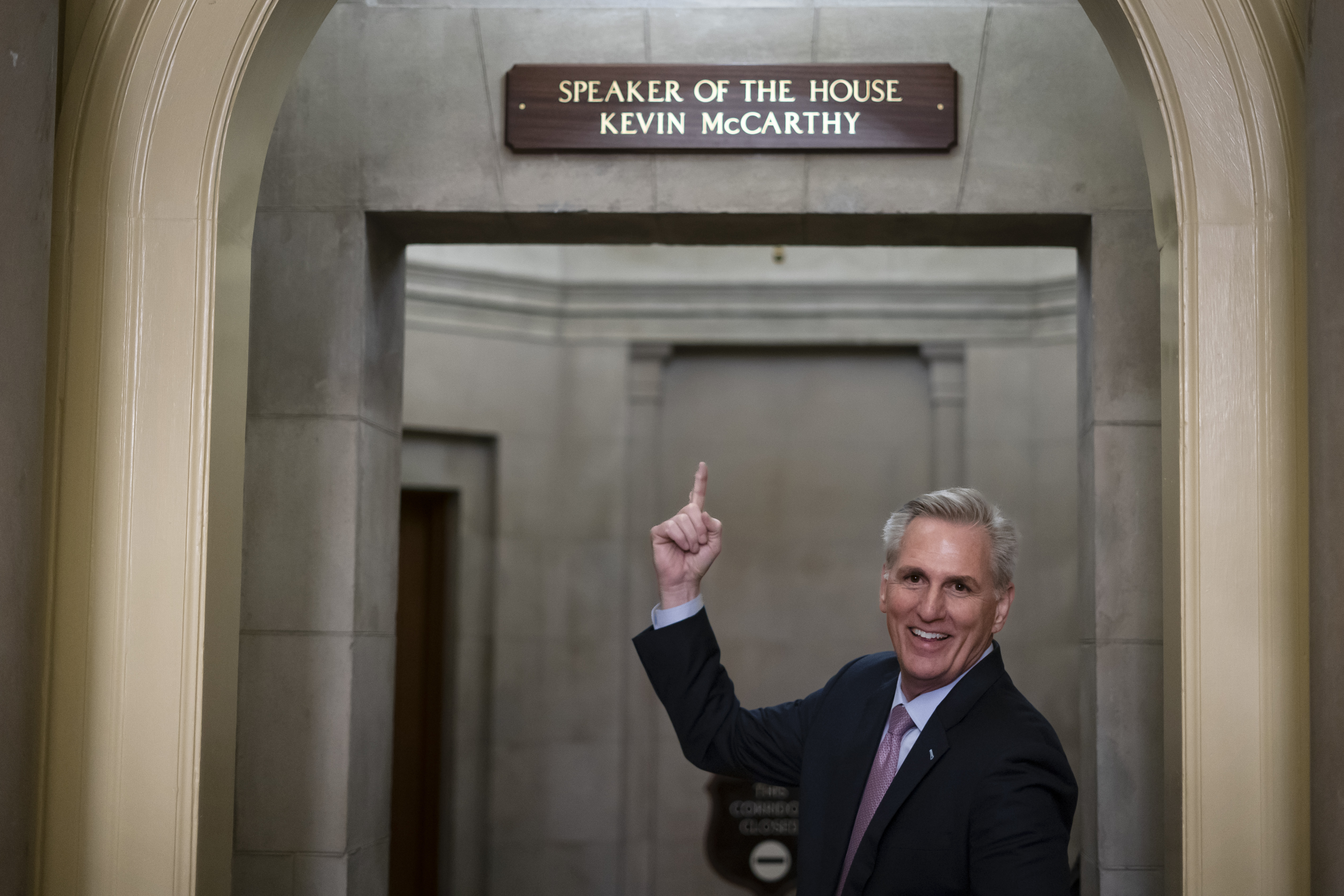 FILE - Then-House Speaker Kevin McCarthy of Calif., gestures towards the newly installed nameplate at his office after he was sworn in as speaker of the 118th Congress in Washington, early Saturday, Jan. 7, 2023. (AP Photo/ Matt Rourke, File)