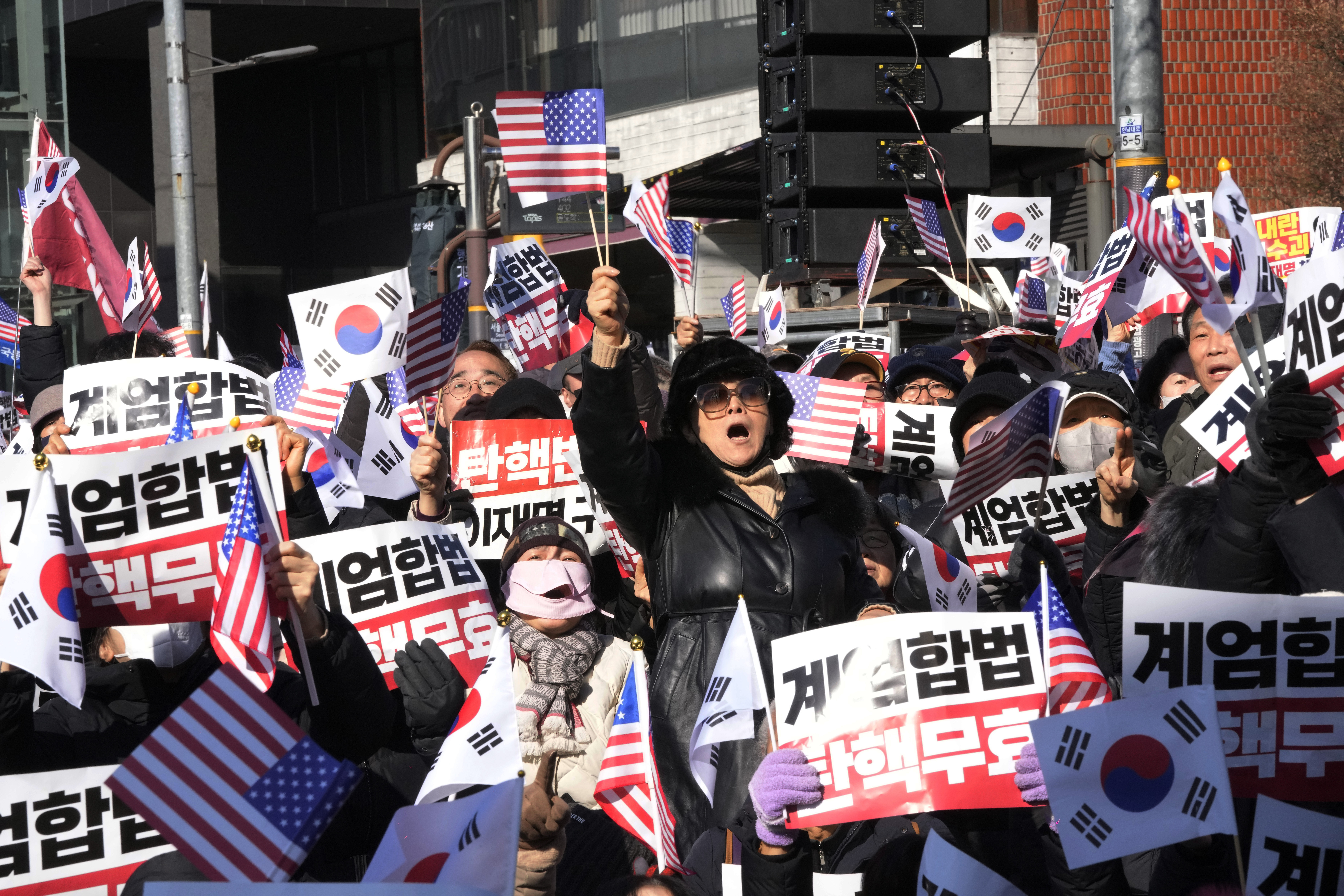 Supporters of impeached South Korean President Yoon Suk Yeol stage a rally to oppose a court having issued a warrant to detain Yoon, near the presidential residence in Seoul, South Korea, Thursday, Jan. 2, 2025. The signs read, "Oppose impeachment." (AP Photo/Ahn Young-joon)