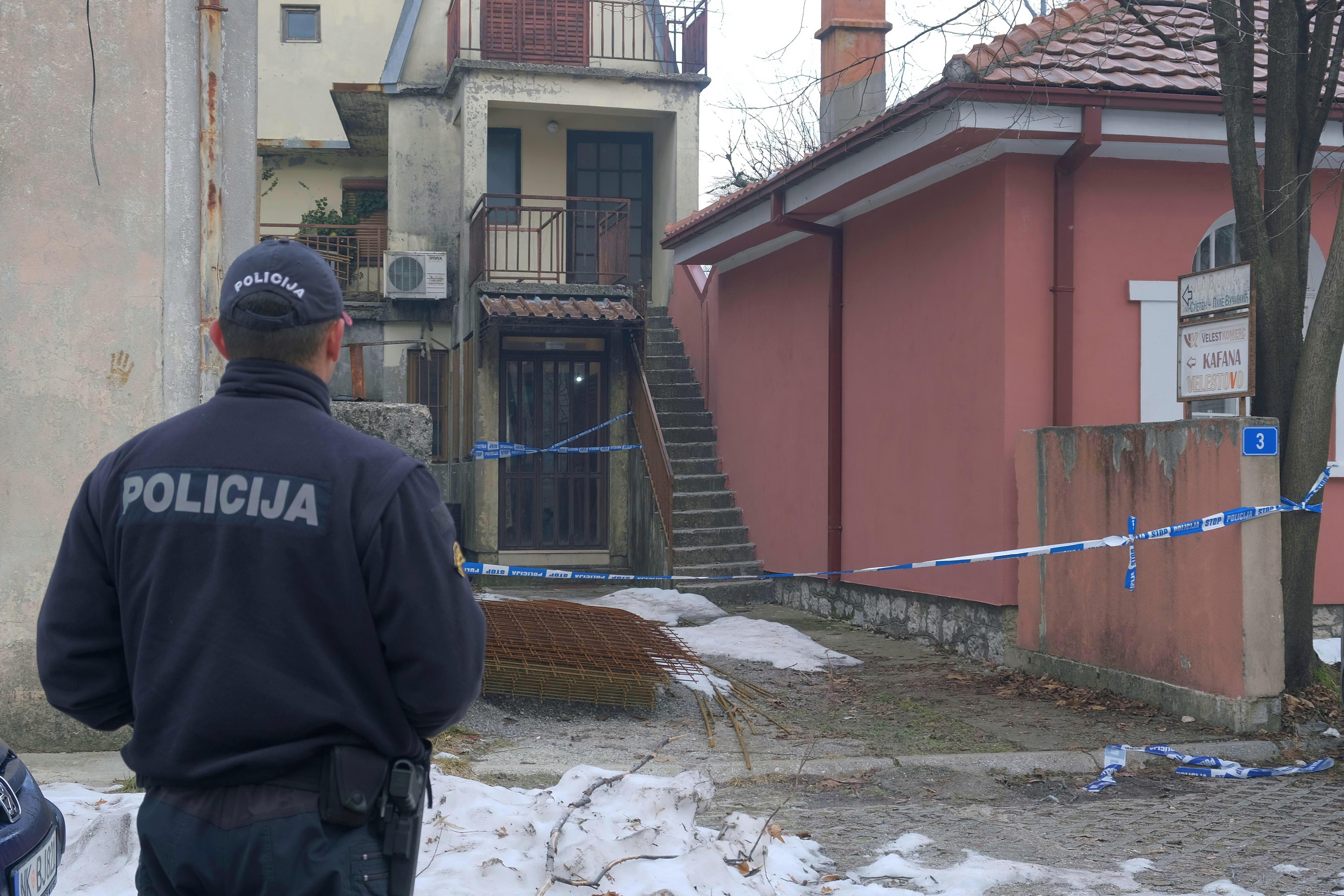 A police officer stands guard at the scene after a shooting incident at a bar, in Cetinje, 36 kilometers (22 miles) west of Podogrica, Montenegro, Thursday, Jan. 2, 2025. (AP Photo/Risto Bozovic)