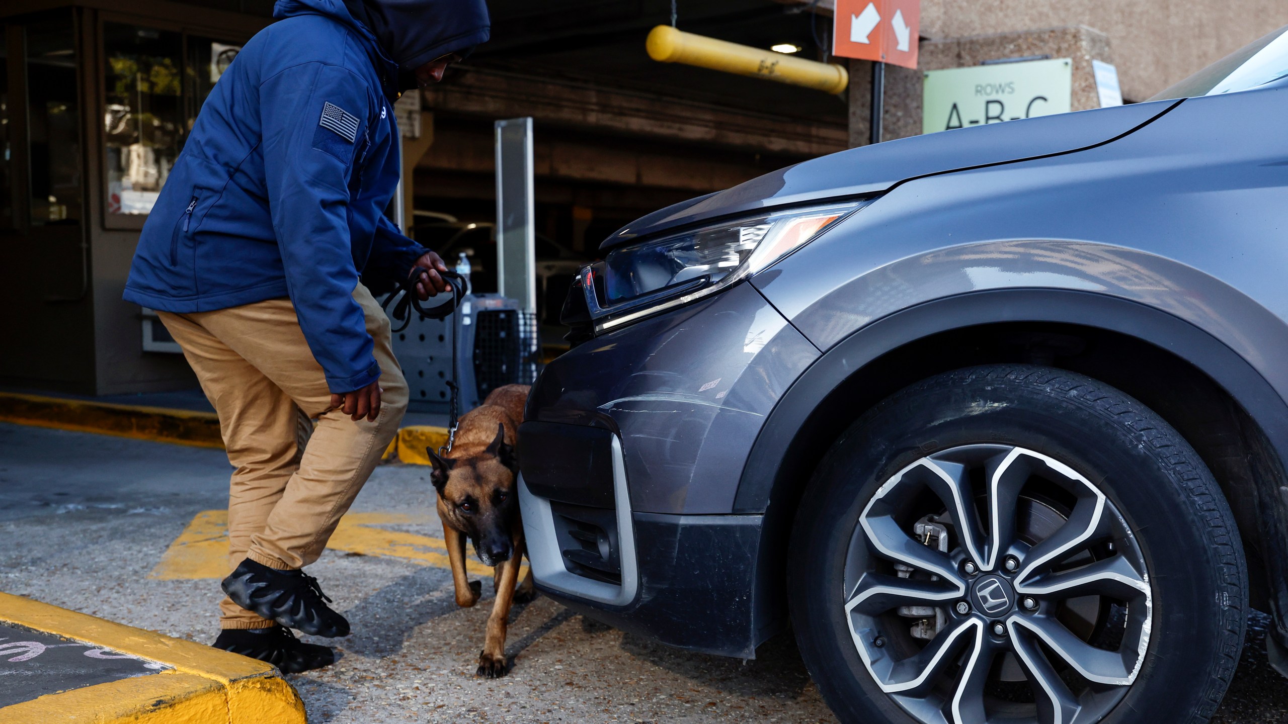 Security and bomb sniffing dogs check vehicles as they enter the Superdome parking garage ahead of the Sugar Bowl NCAA College Football Playoff game, Thursday, Jan. 2, 2025, in New Orleans. (AP Photo/Butch Dill)